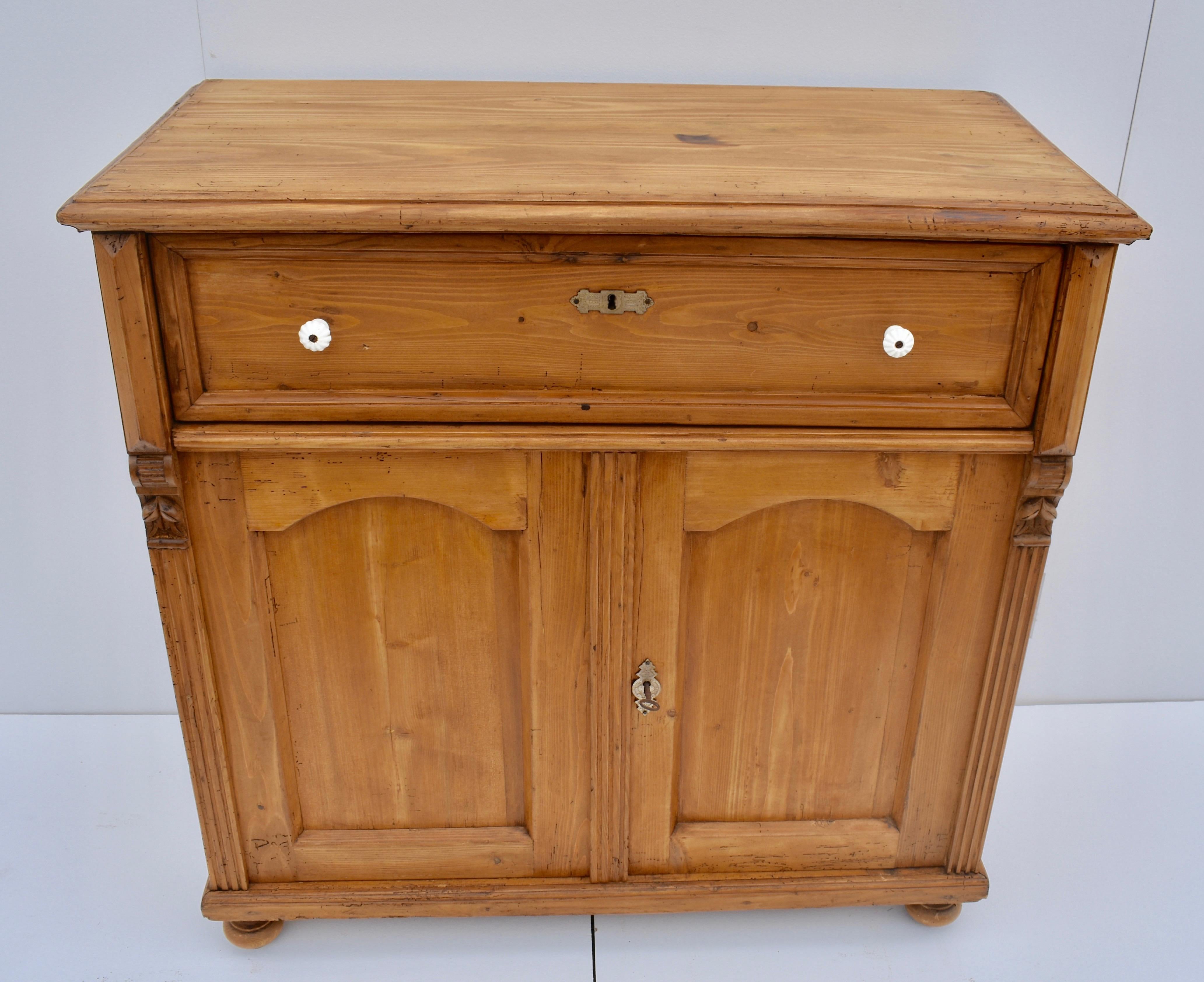 This is a fairly large two-door dresser base, very attractive with a great honey pine color. The top has a step-down routed edge and shows nicely executed exposed dovetails. It has a single long handcut dovetailed drawer, above two arched