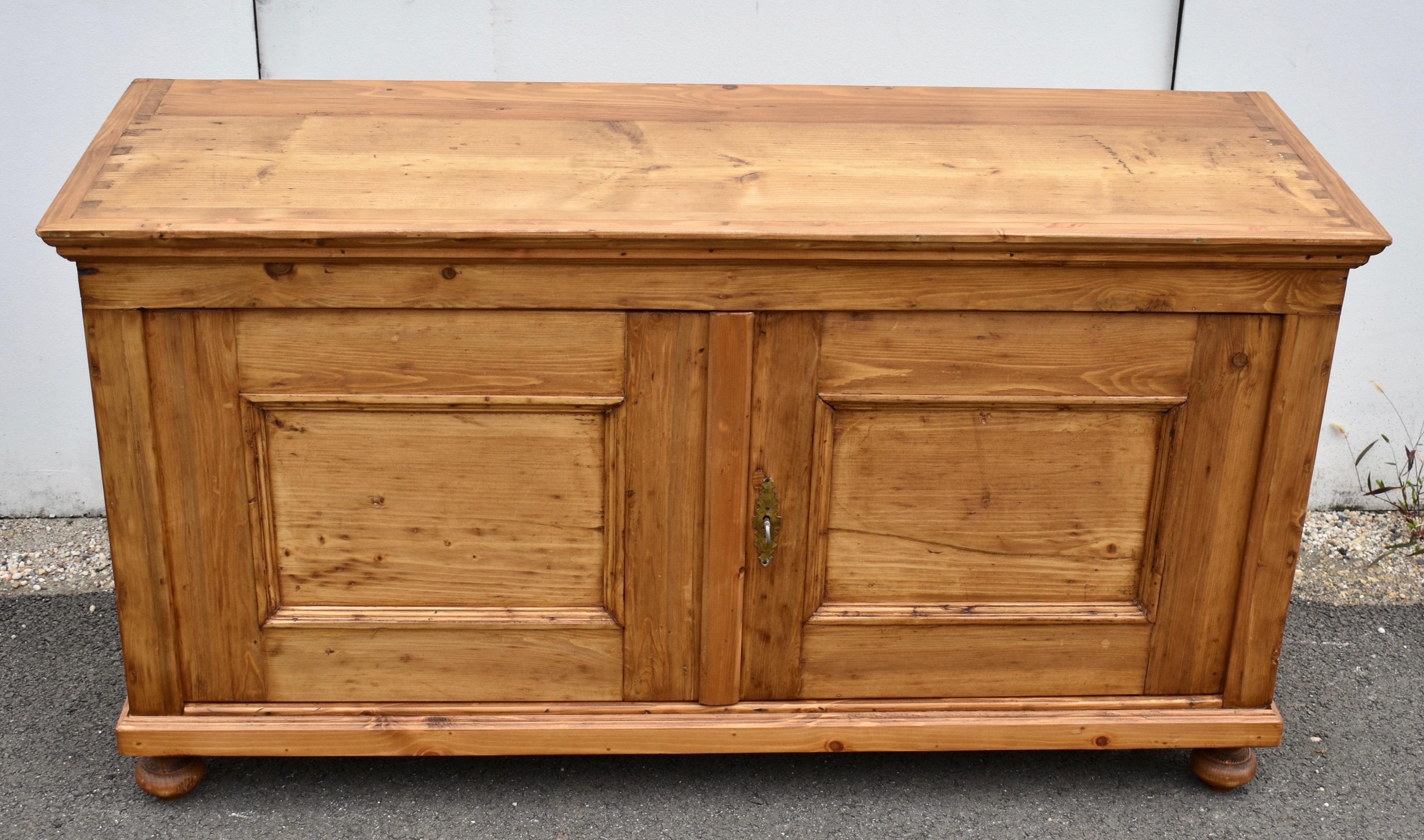 This pretty little dresser base once had a gallery, as is evidenced by the pattern of exposed dovetails on the top.  It is now perfectly flat with great dimensions for a TV stand.  Devoid of any decoration, the doors are sturdily built with broad