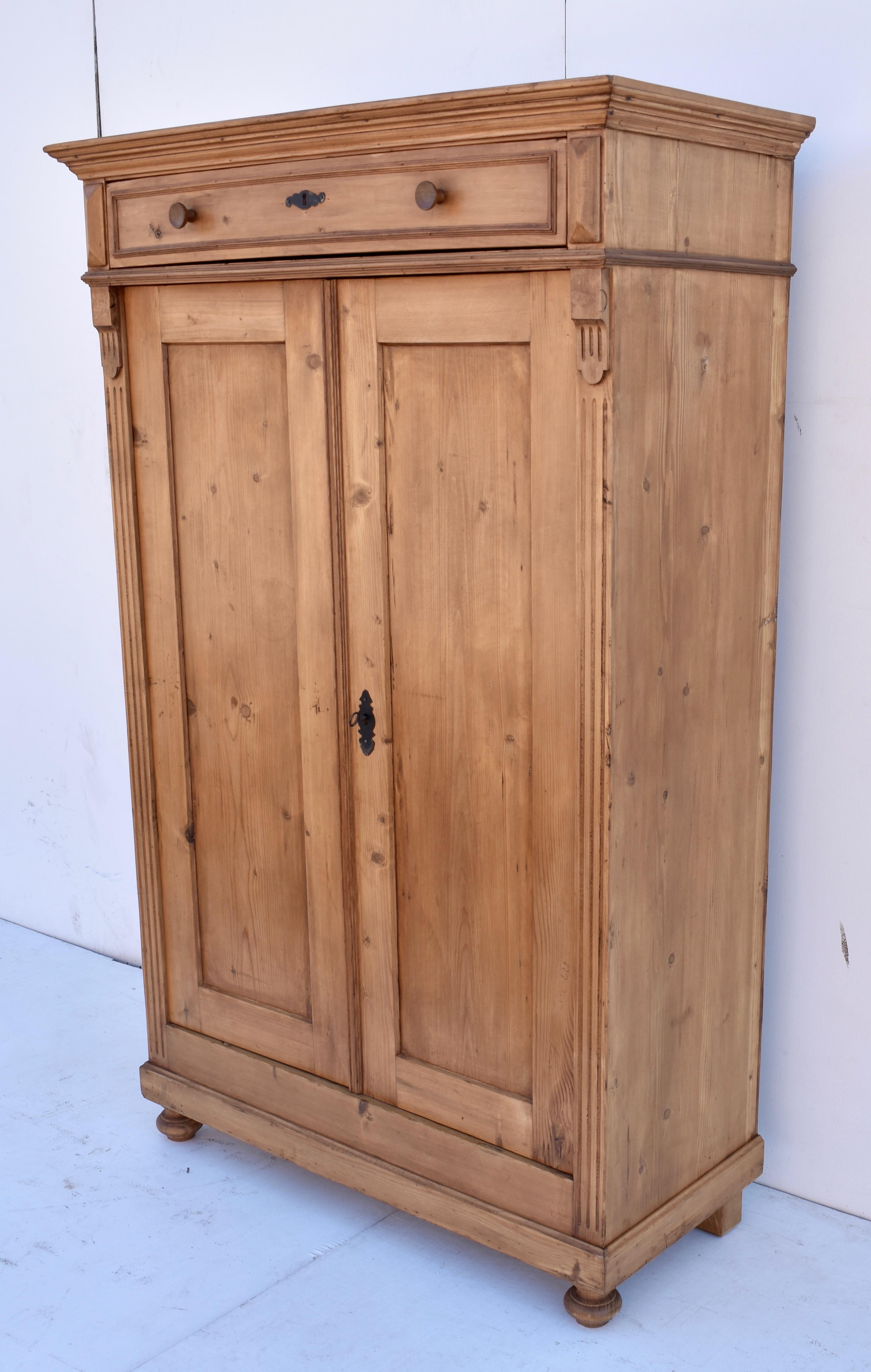 This handsome piece is configured like a “vertigo” or vertical cabinet, with a shallow hand-cut dovetailed drawer above two flat paneled doors. It has been used as a small wardrobe, fitted with a pole on which hangers can be accommodated by hanging