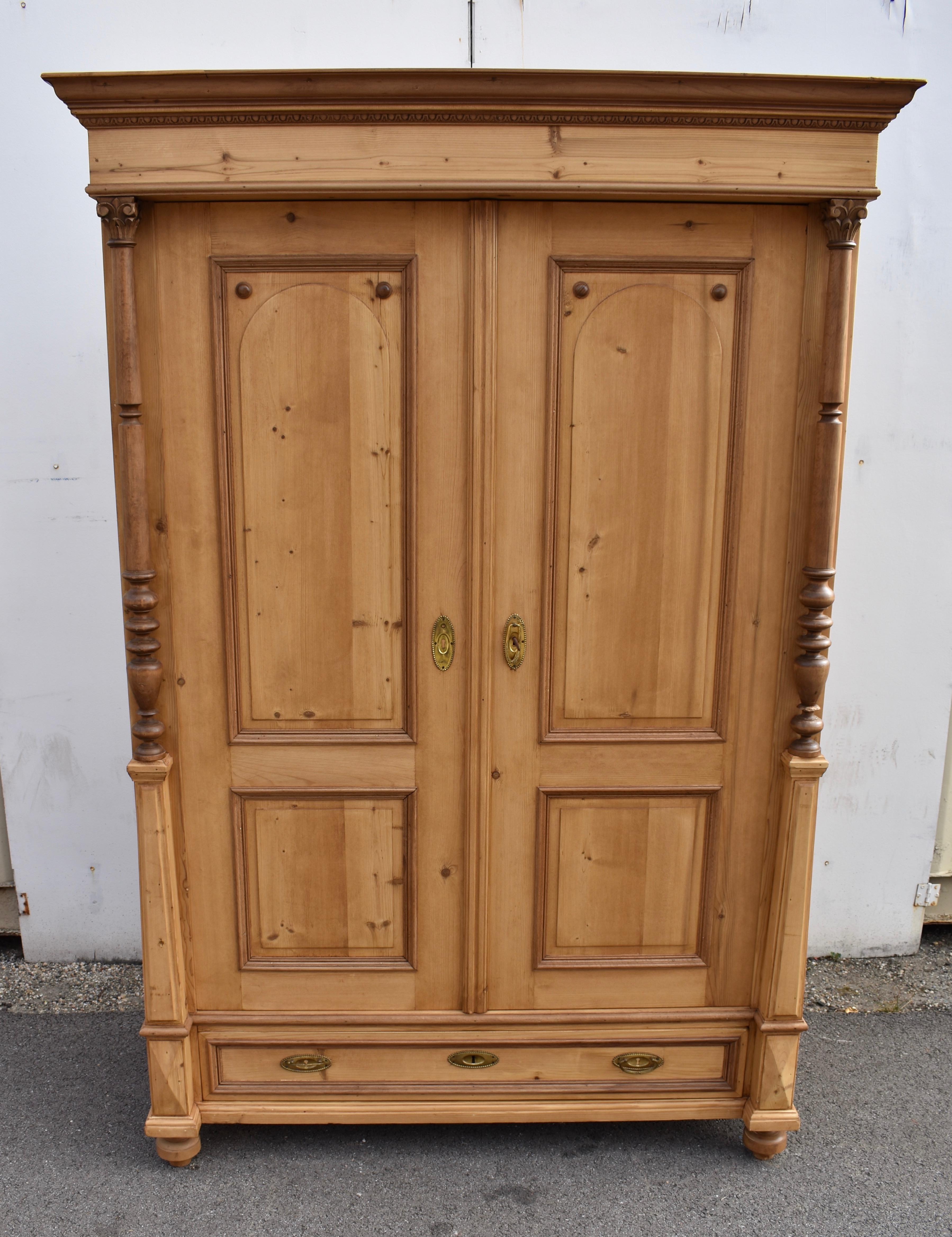 Che bell'armadio!  Questo armadio in legno di pino ha un aspetto fantastico grazie all'uso generoso del legno duro.  Una modanatura a corona ogee in legno duro si collega al fregio superiore, seguita dopo un breve spazio da una fila di modanature a