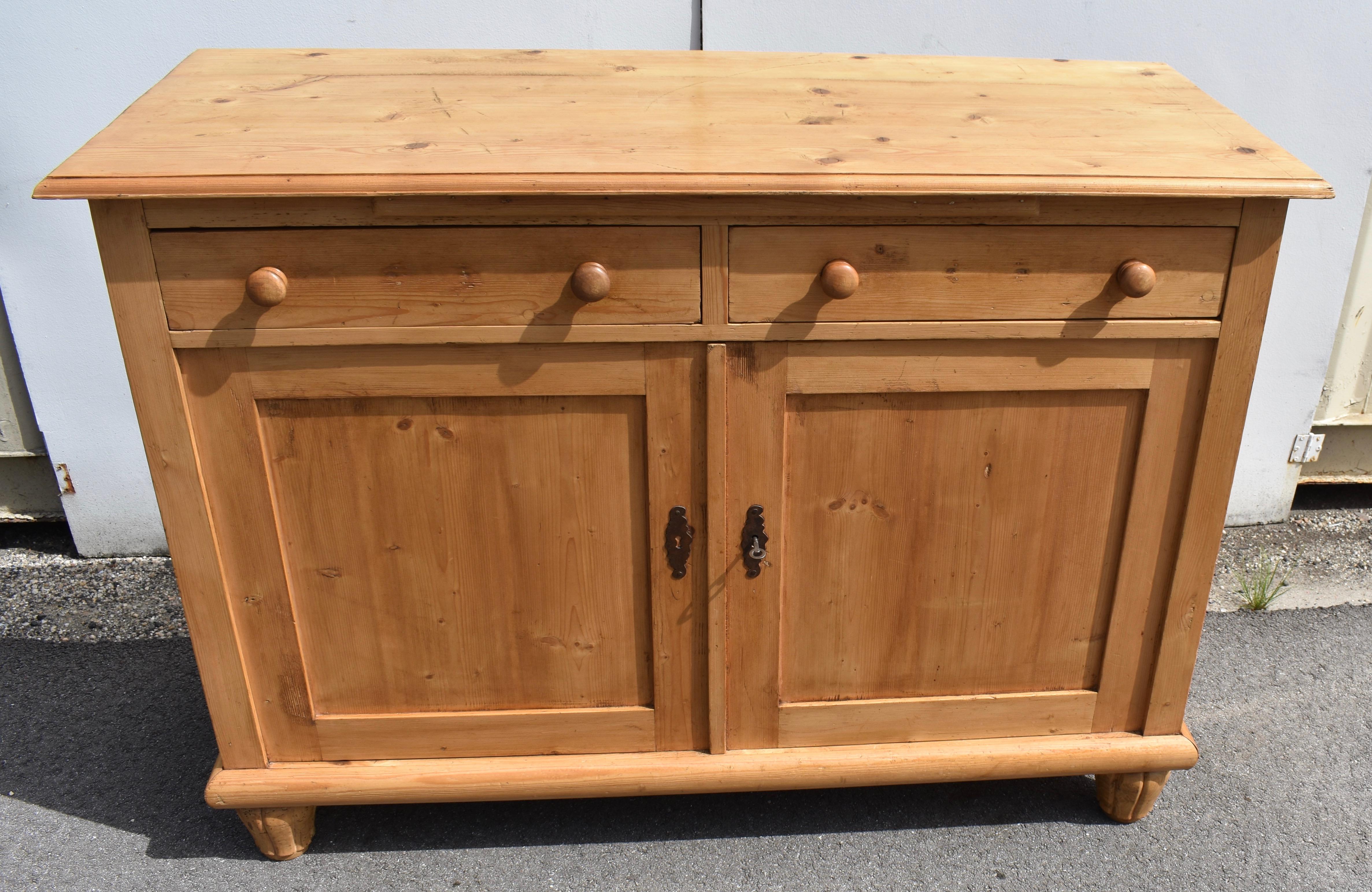 This handsome turn of the century Dutch sideboard is characterized by straight lines and light-colored wood with only very small knots.  The top has a step-down routed edge and has a pull-out bread board mounted underneath.  The two hand-cut