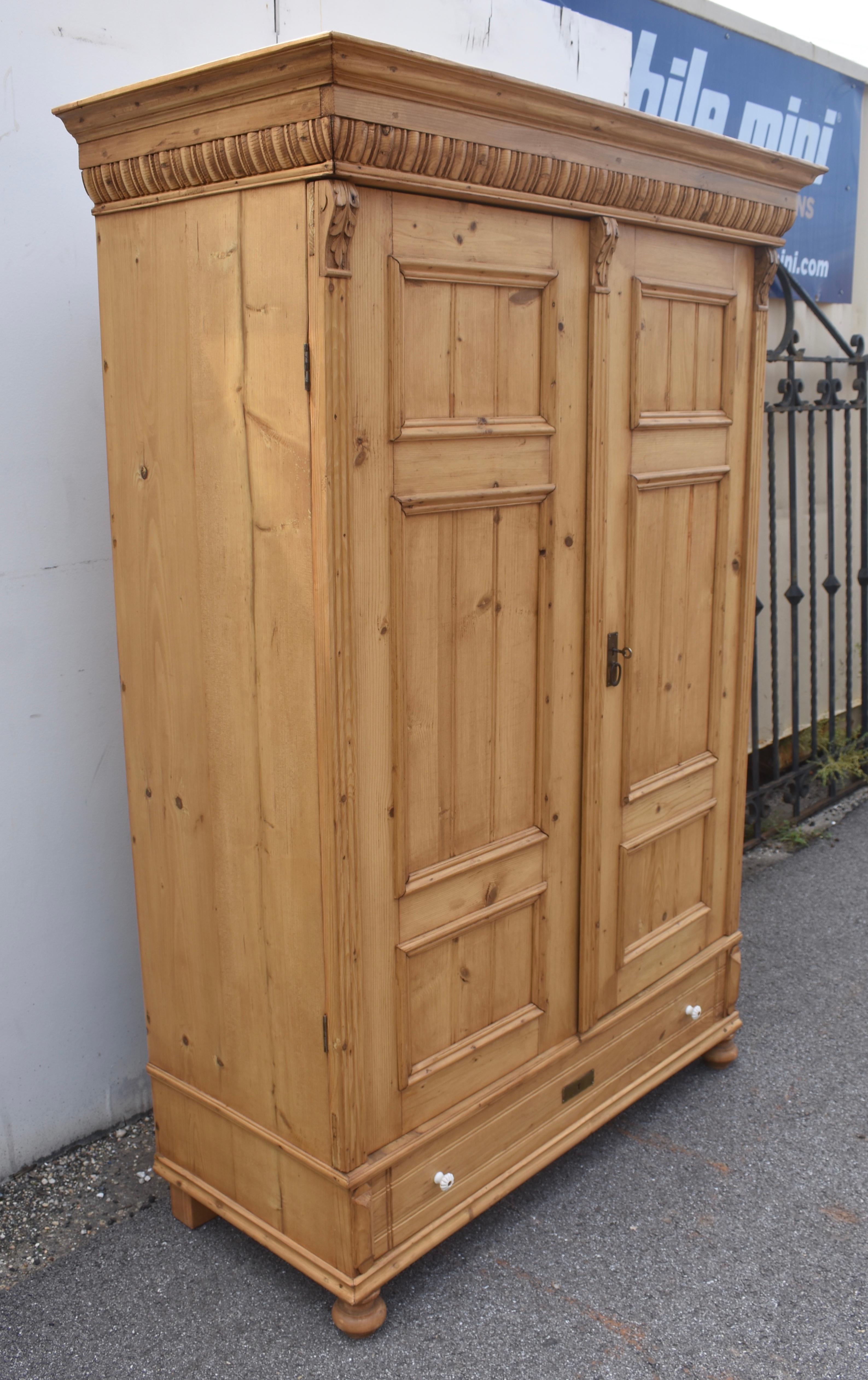 What a beautiful armoire!  The wide crown molding comprises the graceful curves of an ogee molding, mounted on a row of gadrooning.  The two doors each have three panels, a long one in the center with a short one above it and beneath.  Each panel