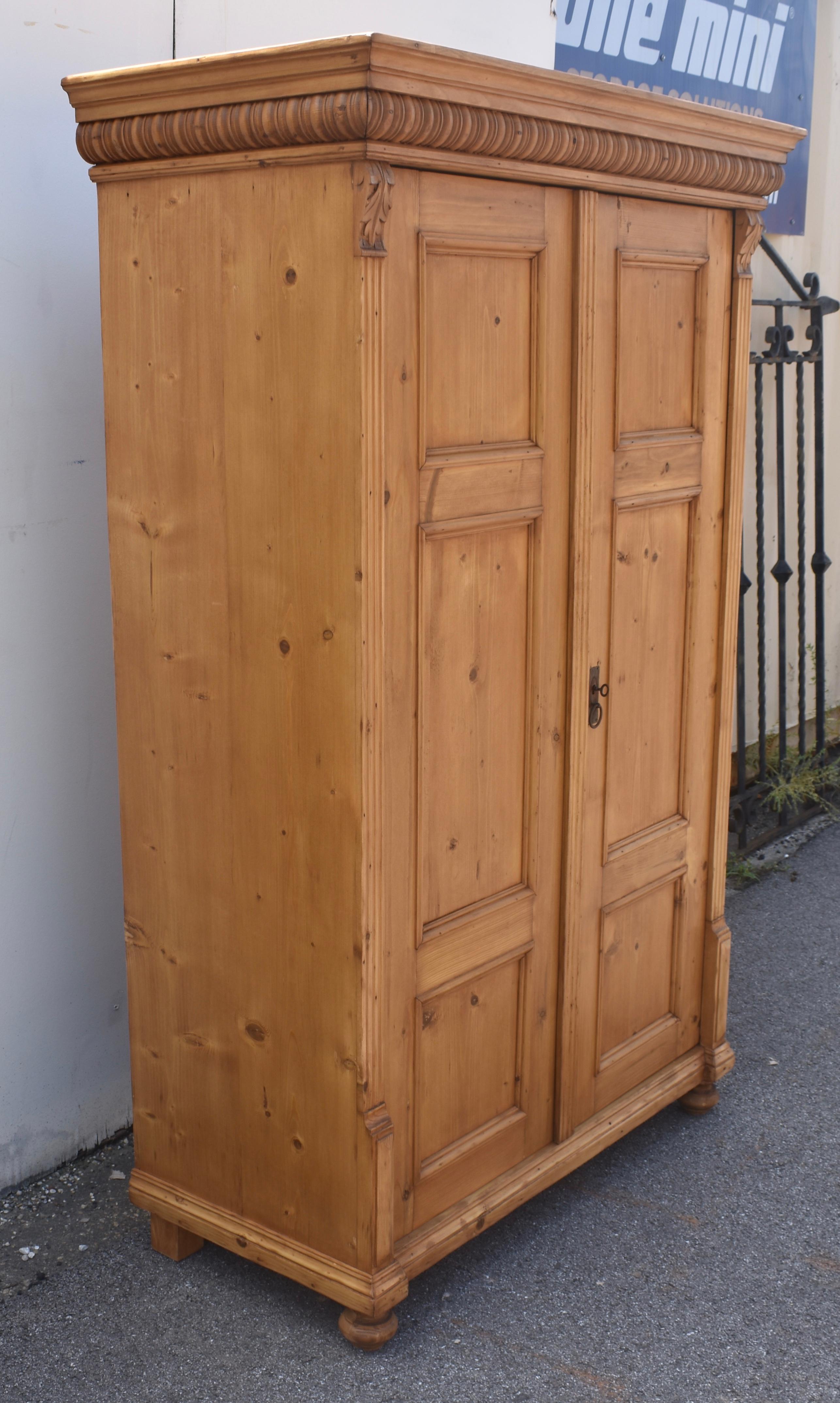 This good-looking two door armoire has a lovely honey color, relatively clear wood and an attractive grain pattern, as well as most of the features we like to find in a Central European antique wardrobe.  The pretty crown is comprised of a classic
