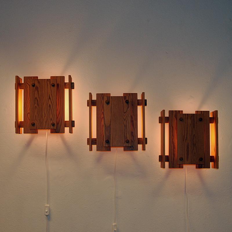 Norwegian set of three wall lamps made of lovely pine wood. These very unique and special pine lamps model W3076 were designed by Gunnar Næss in 1969 and produced by Høvik Verk in the 1970s Norway. Decorative lamps with a rare calming light perfect