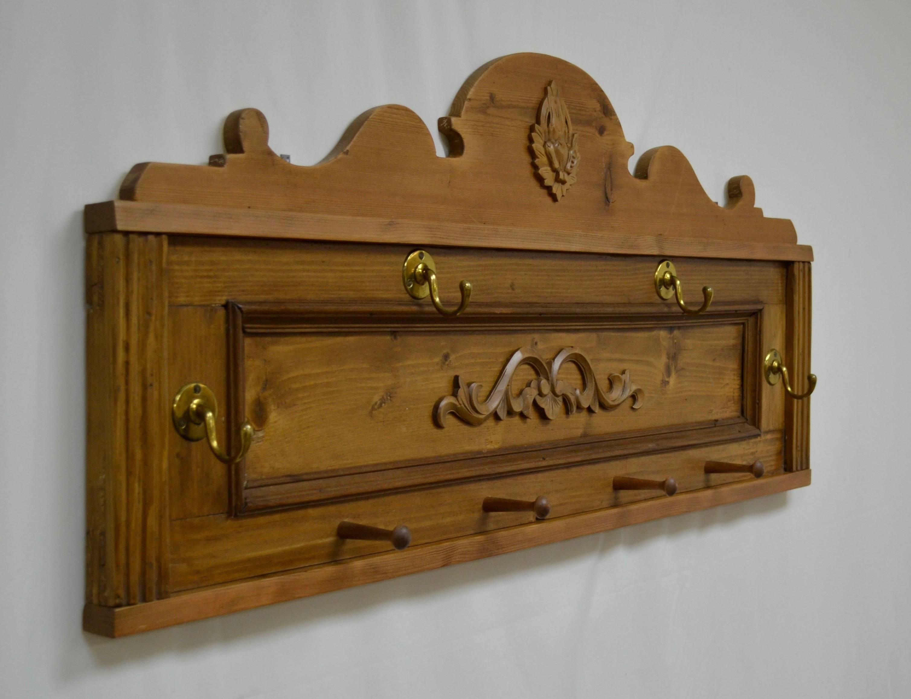 In a creative example of re-purposing, an orphan paneled backboard from an antique pine buffet, complete with its original fluting, has been married to the abandoned crest from an antique pine armoire. The application of two hardwood decorative
