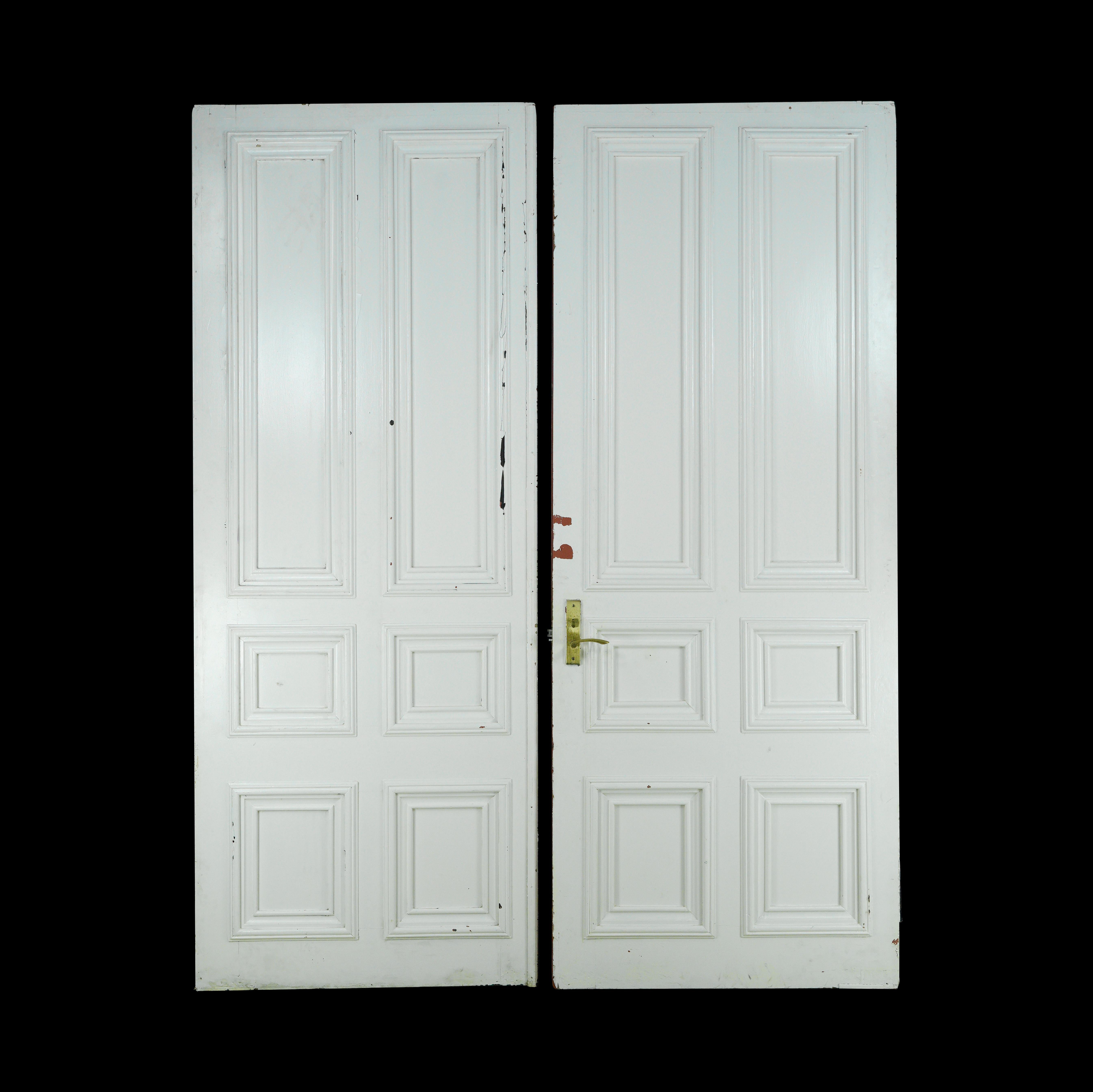 These pine painted white six pane double doors exude classic charm. Their reversible side showcases a tasteful orange pink color paint on one side, adding a unique and vibrant touch to any space. There is some original brass hardware still attached