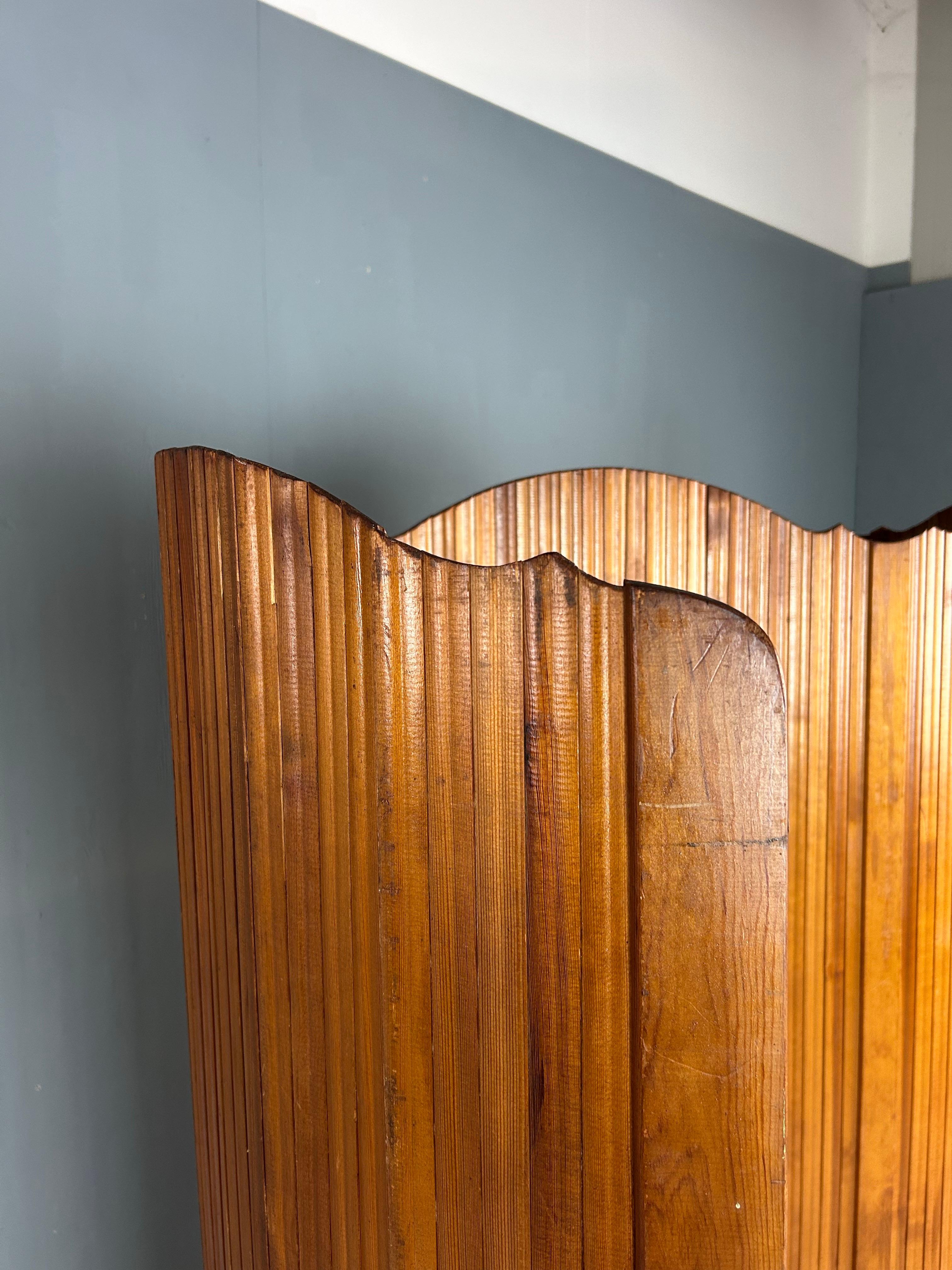 Large 1920s Tambour screen by the French manufacturer S.N.S.A. Made in stained pitchpine.
Its flexible structure allows it to stand freely and shape curves, perfect for a dressing room or as a room divider, can also be rolled up for easy
