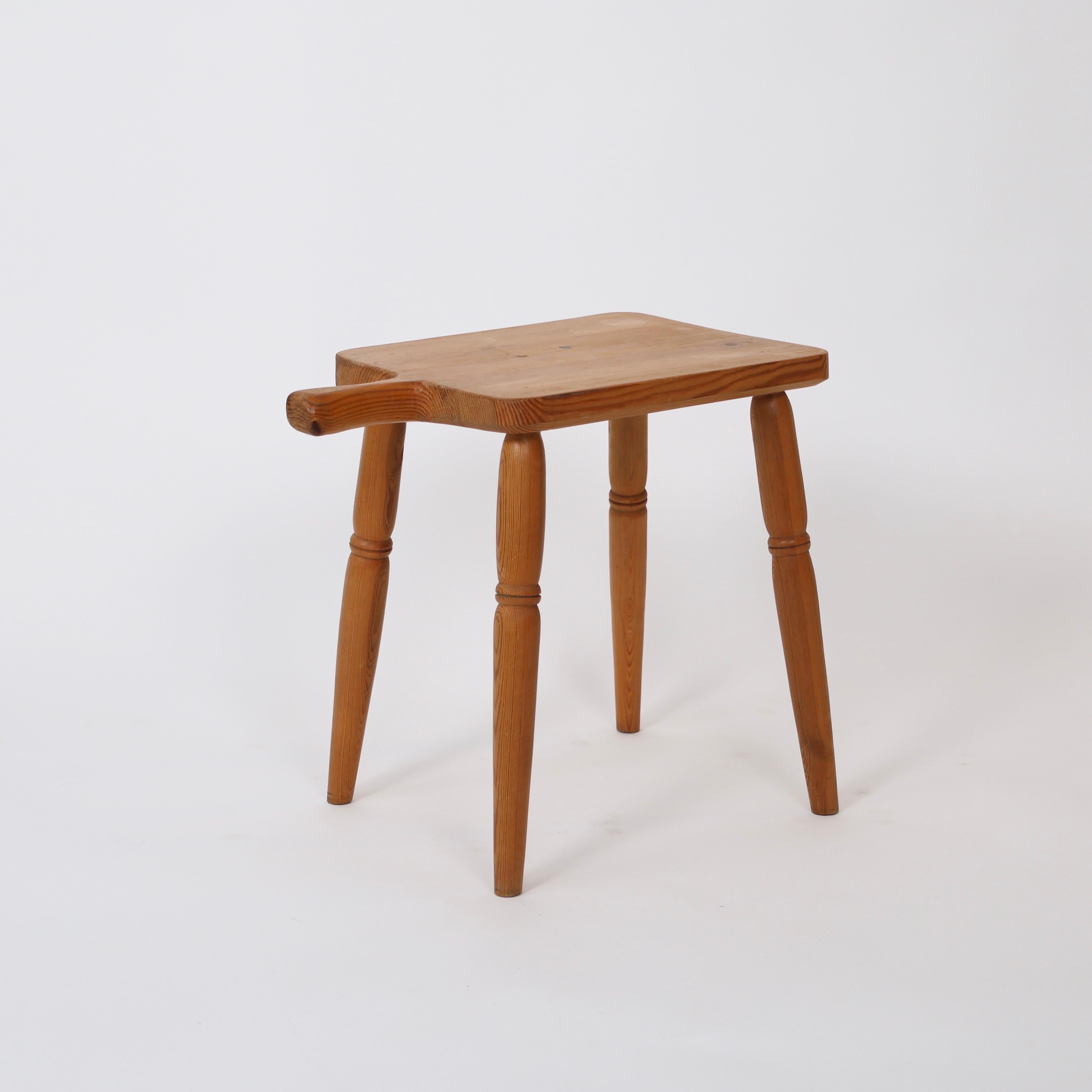 Swedish Modern Pine Stool from the 1970s. A beautiful stool or sidetable to an exquisite home.

* Four-leg stool in solid pine with handle
* Country: Sweden
* Year: est. 1970s
* Condition: Fair vintage condition. The Pine has a nice patina with a