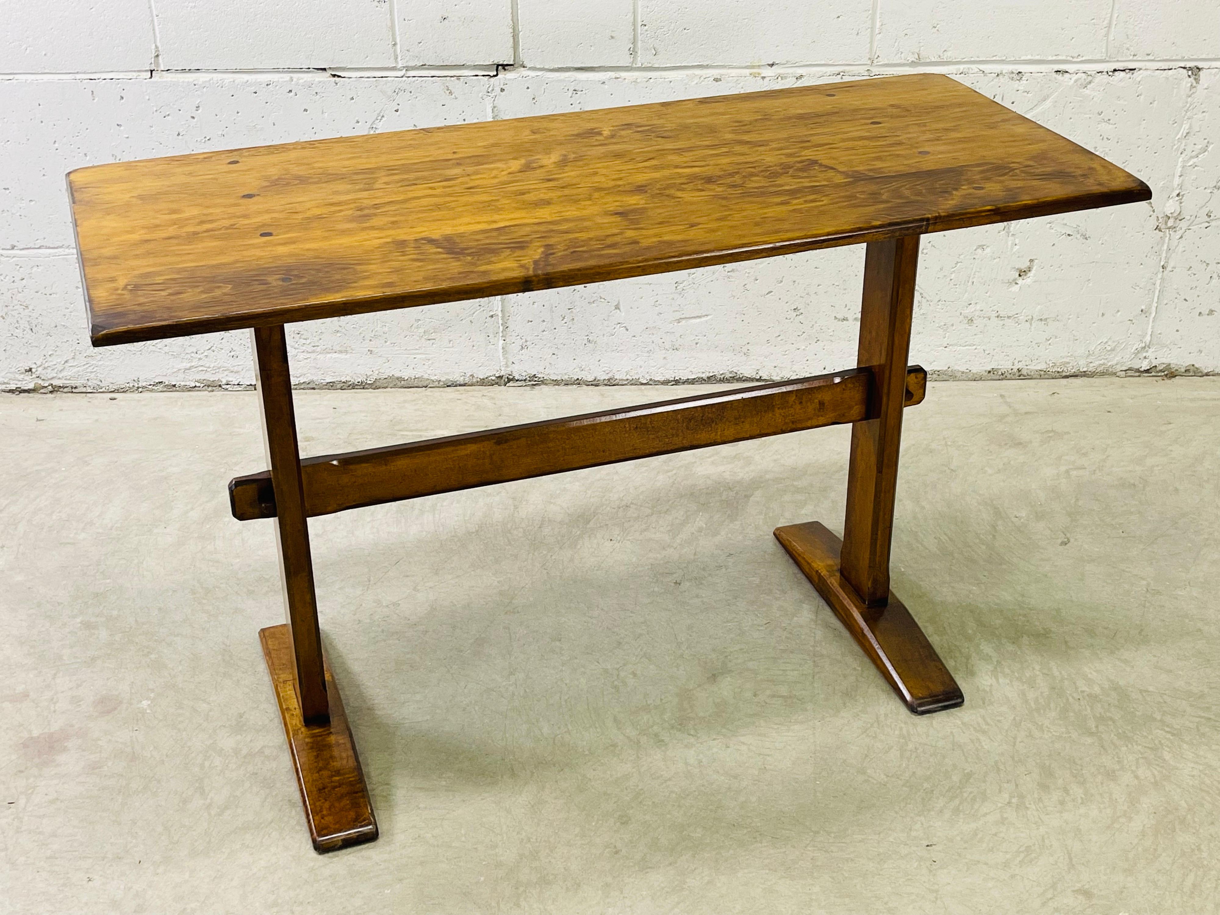 Vintage 1970s pine wood small rectangular trestle table. The table seats four people and has curved table edges. Nice pine wood grain and color. Newly refinished condition. No marks.