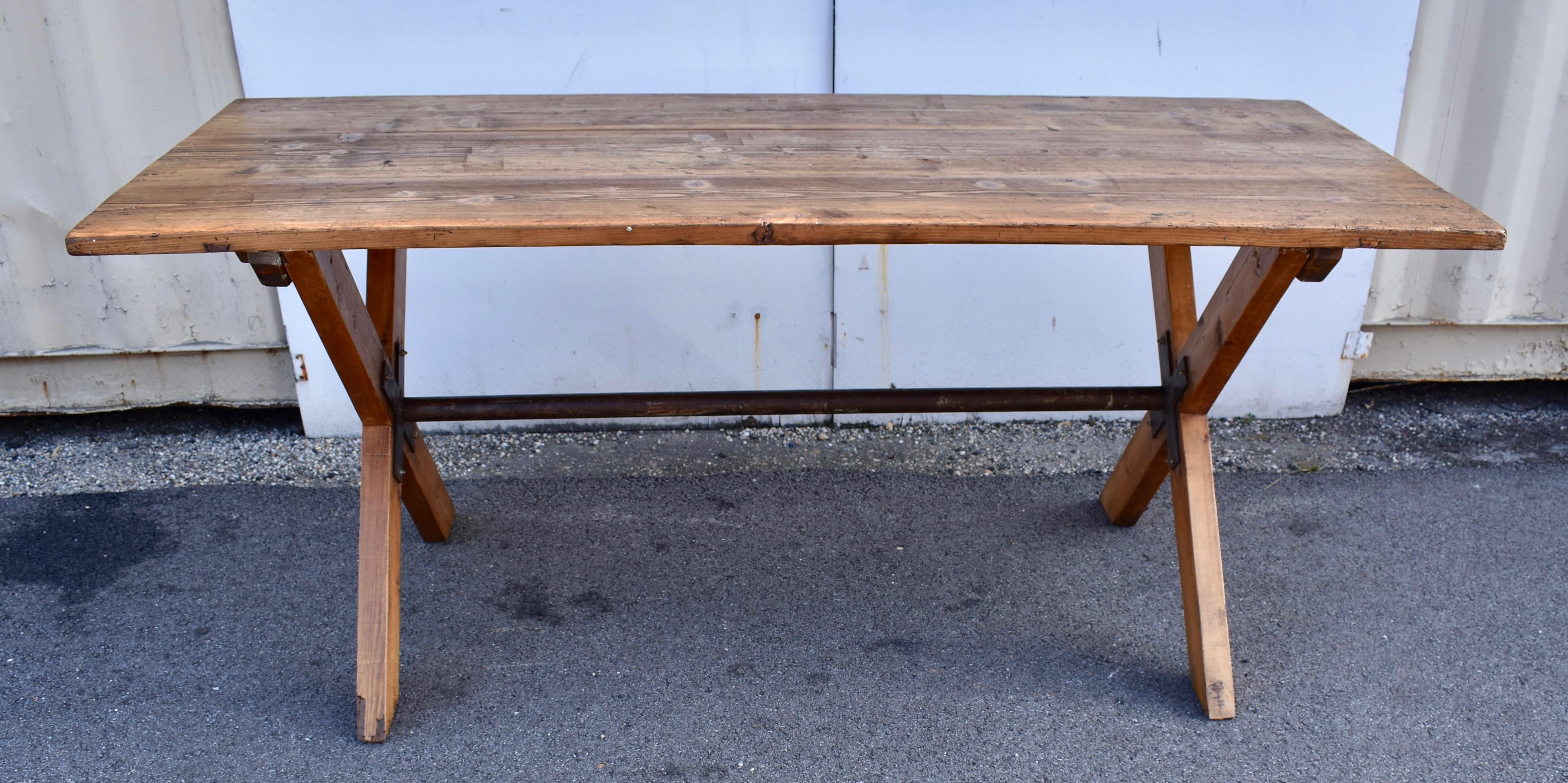 This outstanding late nineteenth century pine table top was in need of a base. Made from three boards nearly 1.5” thick and reinforced with two hardwood cleats dovetailed into its underside, it had been a working surface in a small factory. Our