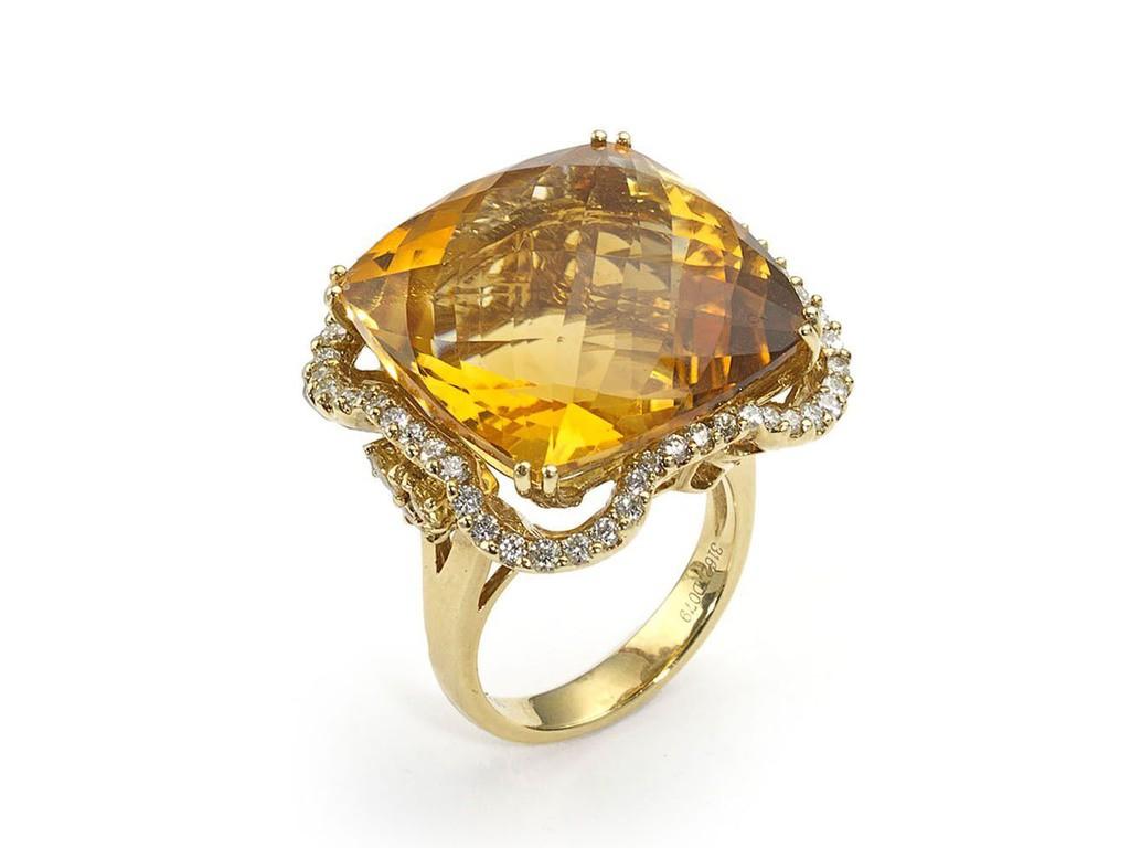 A citrine dress ring, set with a large, square, pineapple-cut citrine, in an undulating surround of round brilliant-cut diamonds, with three citrines set in each shoulder, mounted in 18ct gold. The citrine weighs approximately 31.63ct,  the total