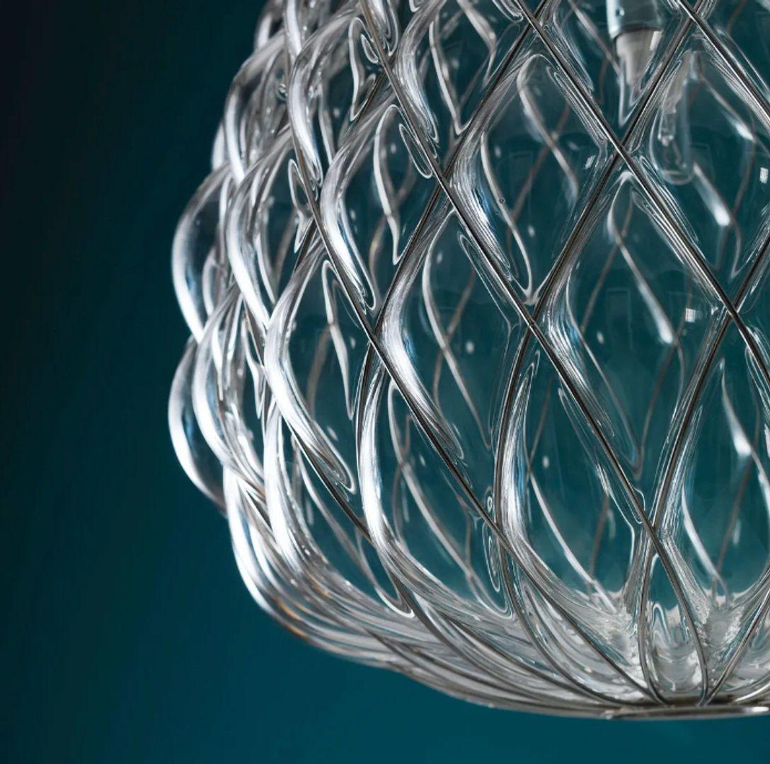 Pinecone - Large Suspension Lamp - Chrome Plated Metal Wire Mesh, Clear Glass Shade

Pinecone is a suspension and table lamp. The diffuser is manufactured using the ancient caged blown glass technique: the glass maker blows the molten glass blob