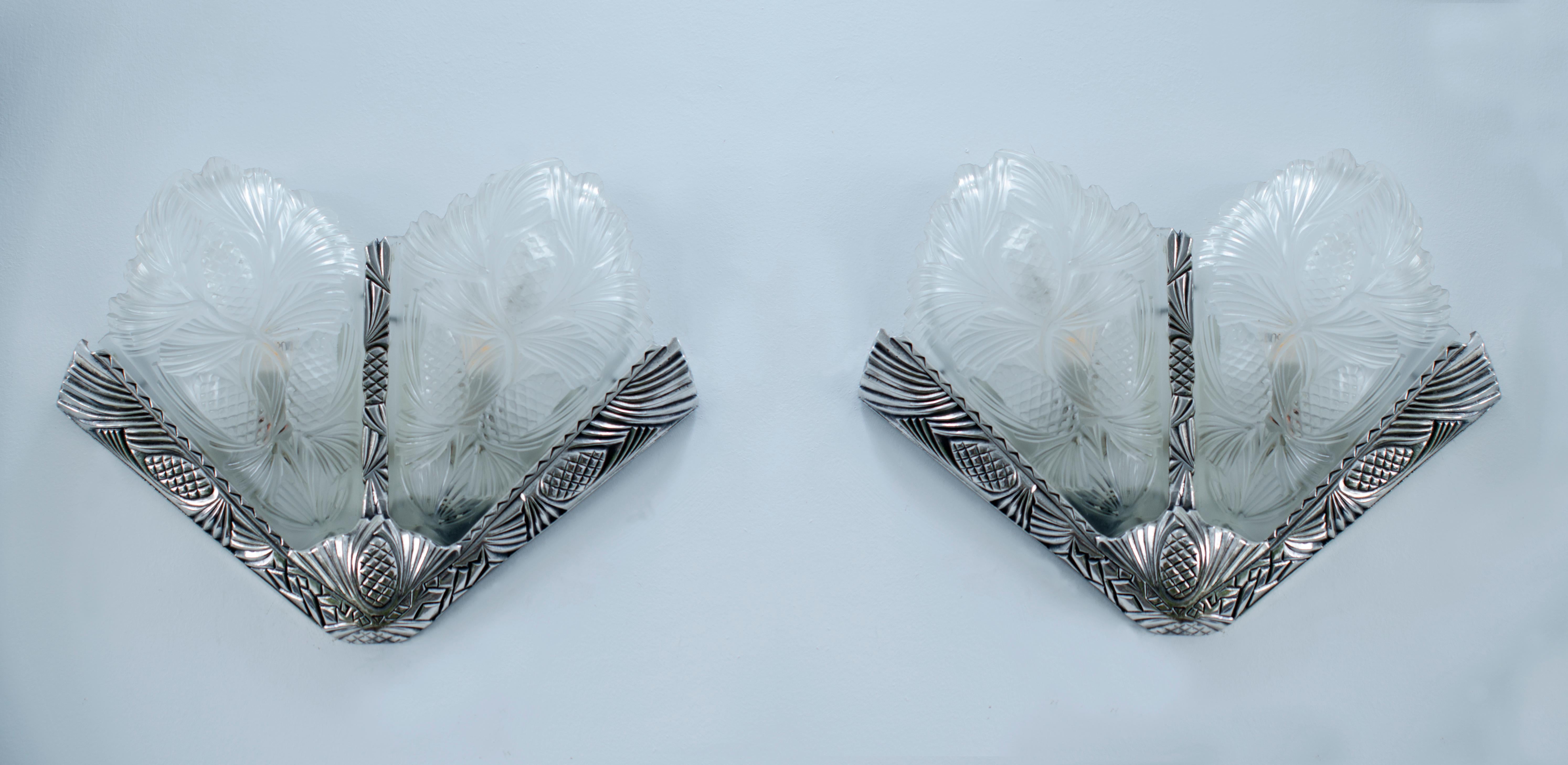 Pair of Art Deco sconces with a bronze frame with carved and silver-plated pinecones, with 2 glass plates, known as 
