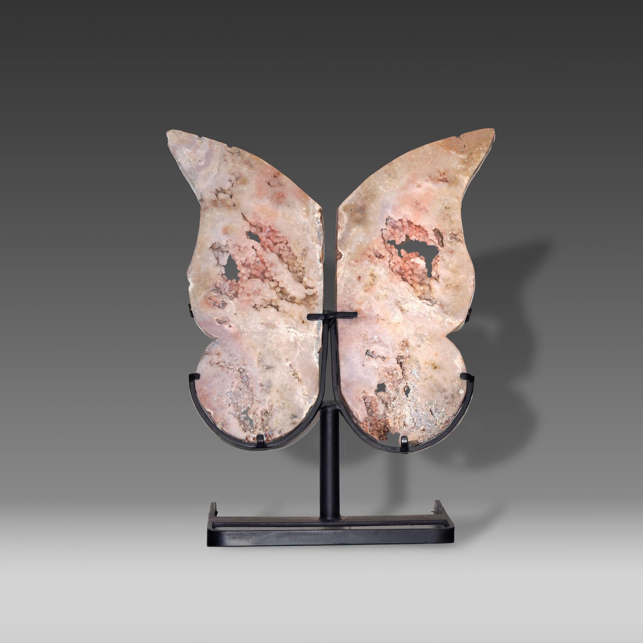 These Pink Amethyst wings have been hand-carved from a single specimen and mounted on a custom black metal stand. Rising 30 inches in height, the piece evokes the form of butterfly wings, balancing artistry with the natural elegance of crystal. Soft