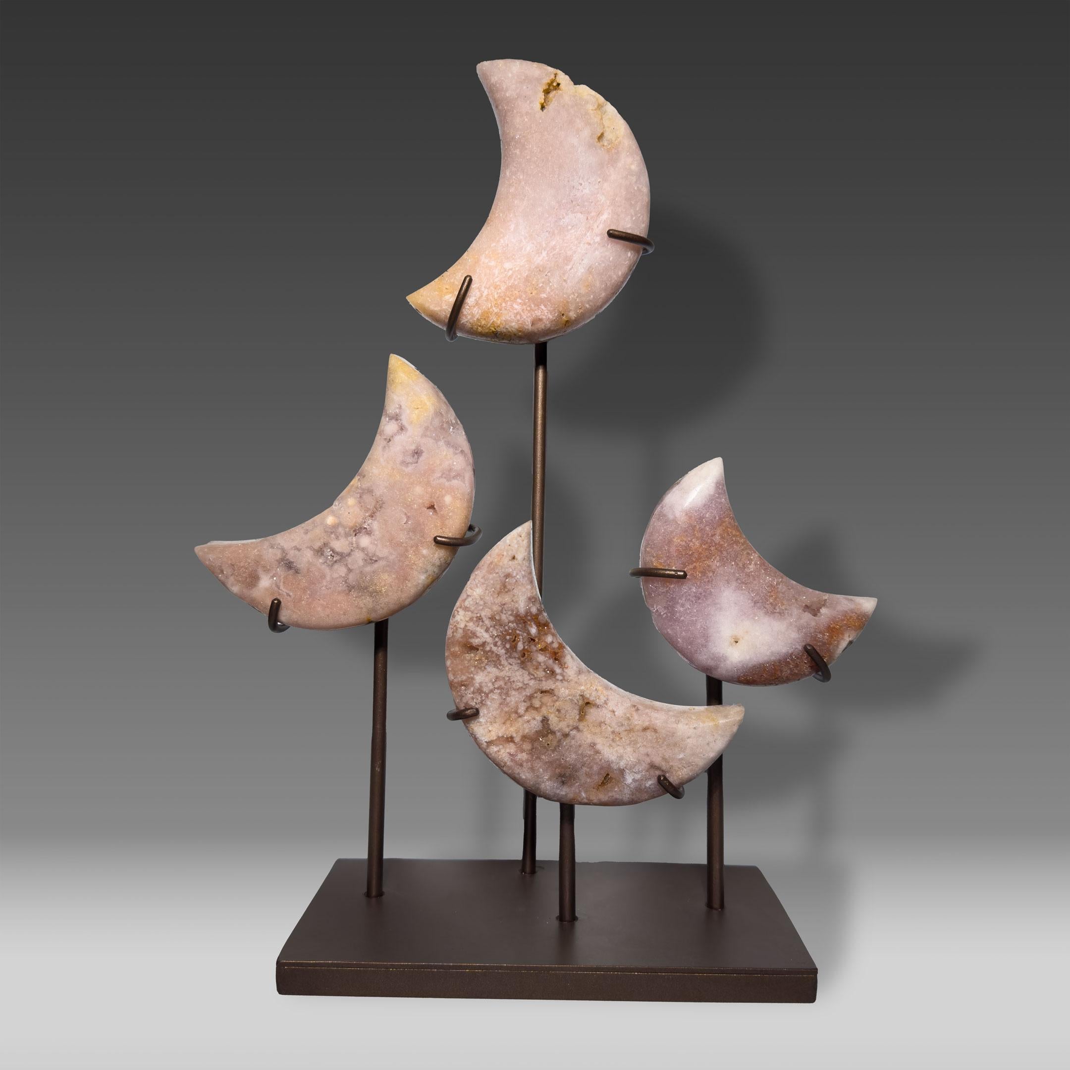 This dreamy Pink Amethyst display showcases four hand-carved crescent moons, each cut from solid, natural stone and arranged in a balanced celestial composition upon a custom metal stand. Subtle shades of lavender, blush, and peach shimmer with