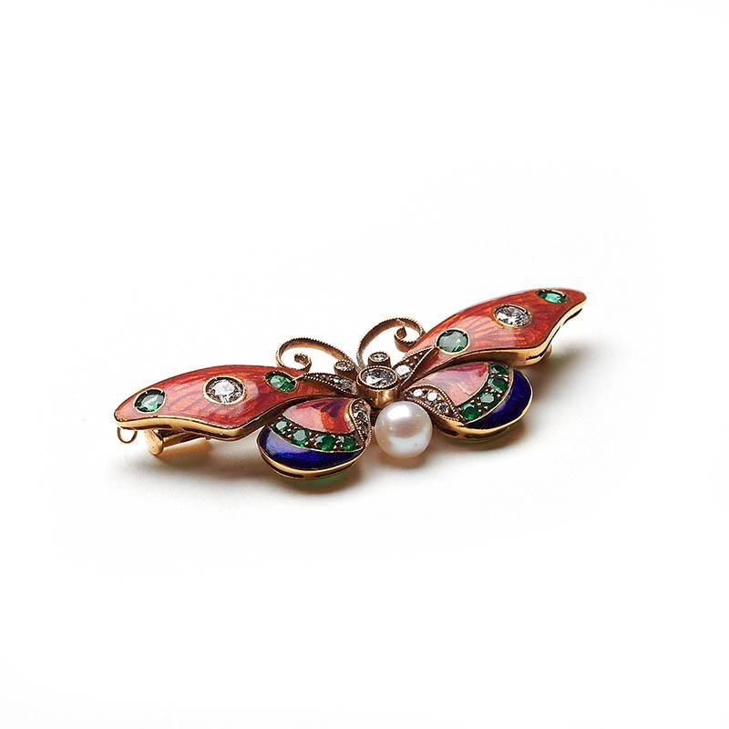 A pink and blue guilloche enamel butterfly brooch set with 0.34ct of round brilliant-cut diamonds and 0.34ct of emeralds, with a pearl, mounted in gold