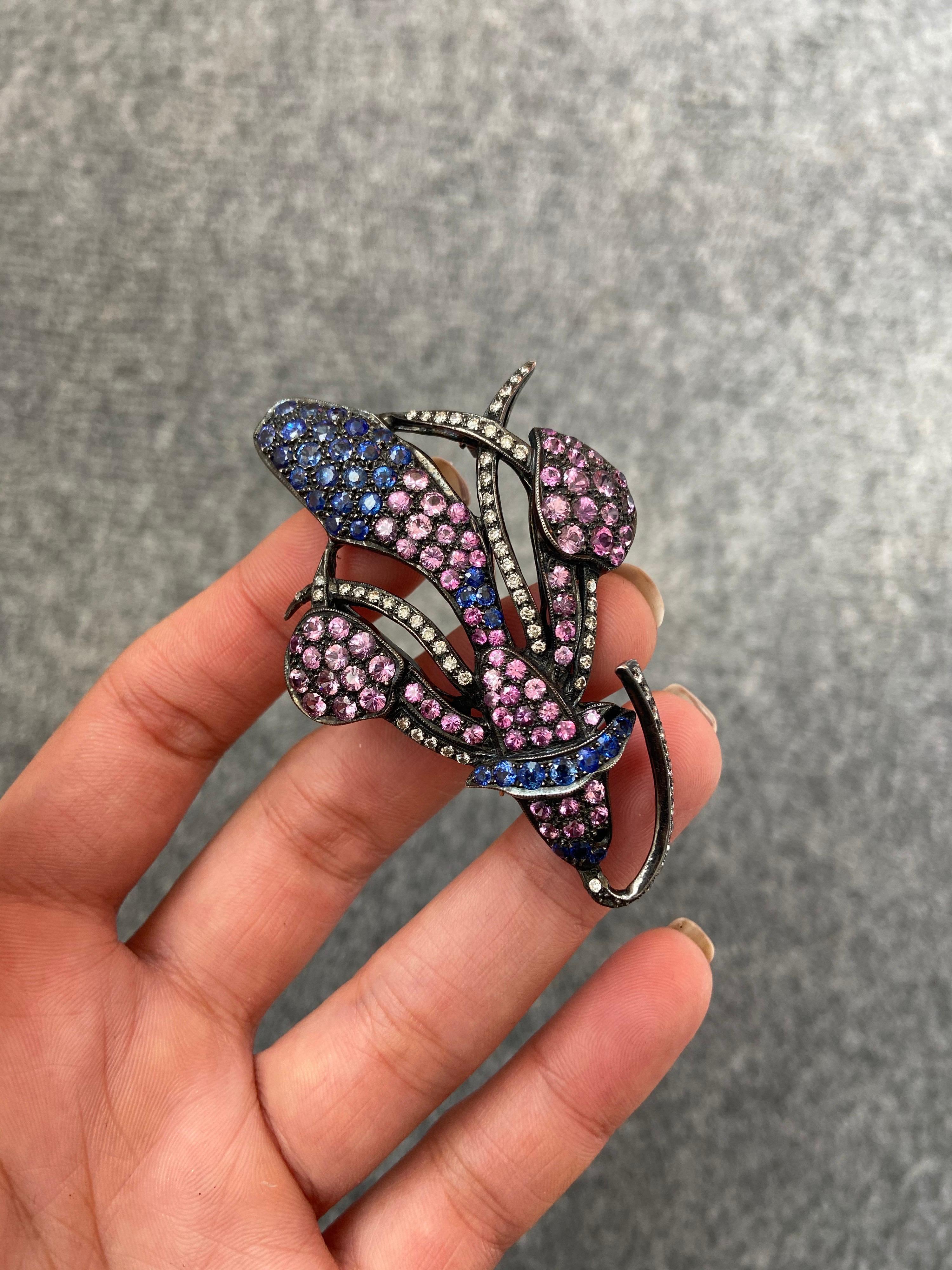 A beautiful, antique looking coloured sapphire and diamond brooch, set in silver. 
There are around 4.8 carats of pink sapphire, 2.2 carats of blue sapphire, and 0.9 carats of diamonds used in this piece. 