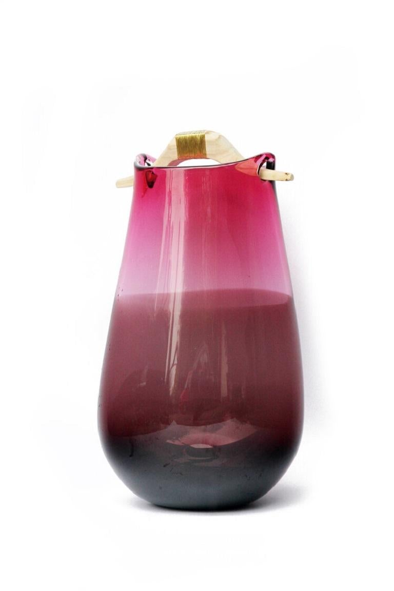 Pink and Brown Heiki vase, Pia Wüstenberg
Dimensions: D 20-22 x H 32-40
Materials: glass, wood, metal wire
Available in other colors.

Inspired by a simple fix on an old sauna ladle handle, fixed with wire and outright everyday genius. Heiki
