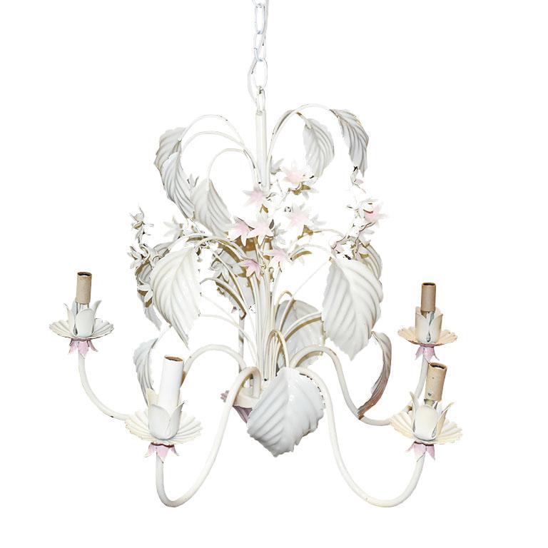 A beautiful topsy-turvy Hollywood Regency palm leaf motif tole chandelier. This whimsical piece of lighting features 5 arms with candlestick bulbs. A cream vine of hand-painted palm leaves wraps around the top of the piece throughout the body. Small