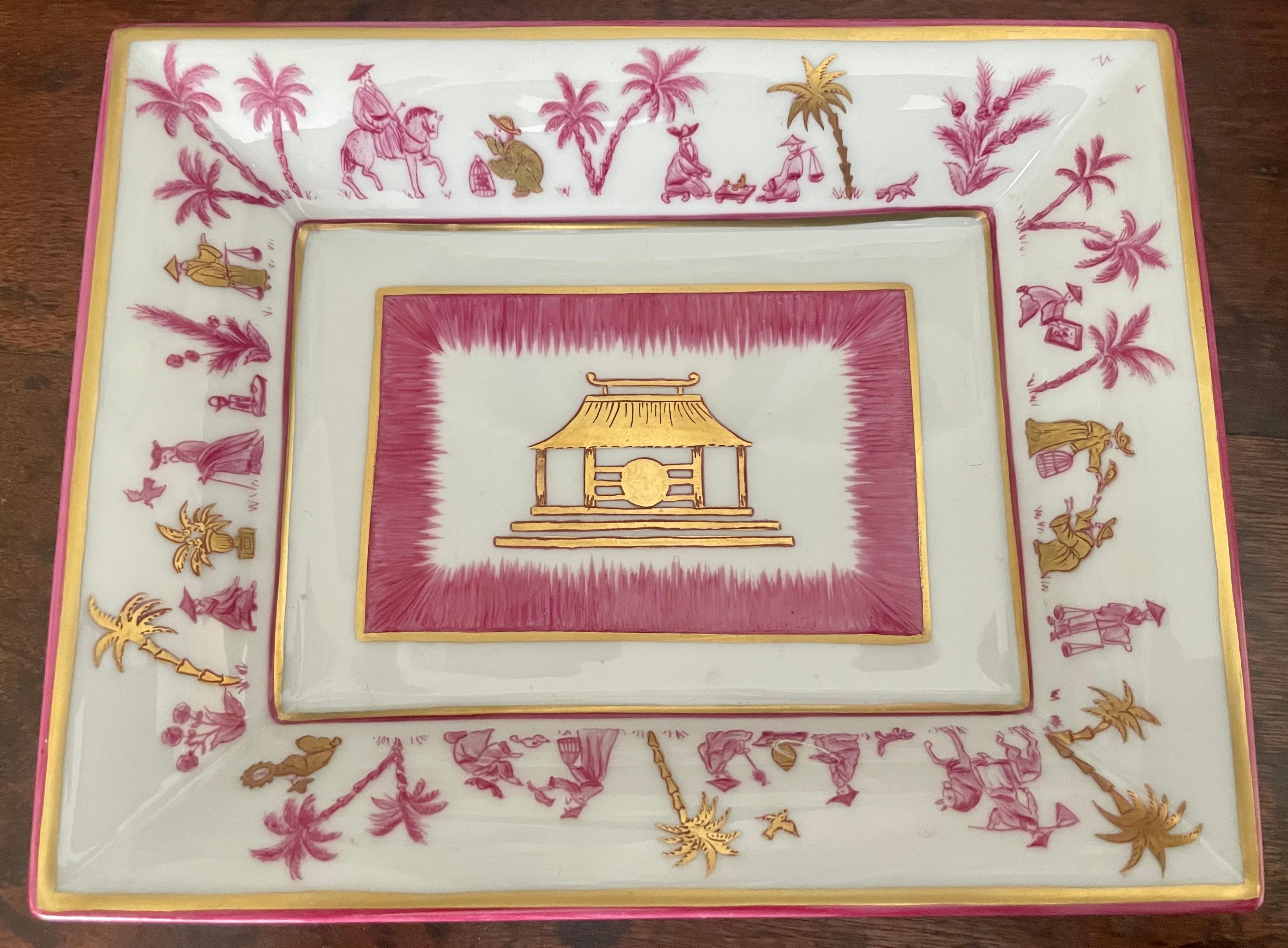 Pink and gold Chinoiserie vide-poche. French porcelain raspberry pink and gold painted ashtray with central gold pagoda pavilion with raised out curving pink and gold banded border with palm trees and chinoiserie figures; stamped Limoges. France,