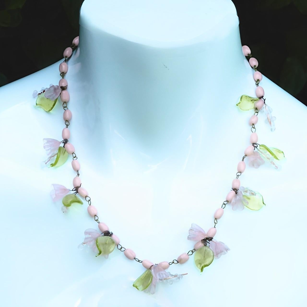 Lovely pink and green glass bead necklace, featuring green glass leaves, pink flowers and bud stalks. Measuring length 46.5 cm / 18.3 inches. The necklace is in very good condition, there is a chip to a leaf at one end, and there may be a flower is
