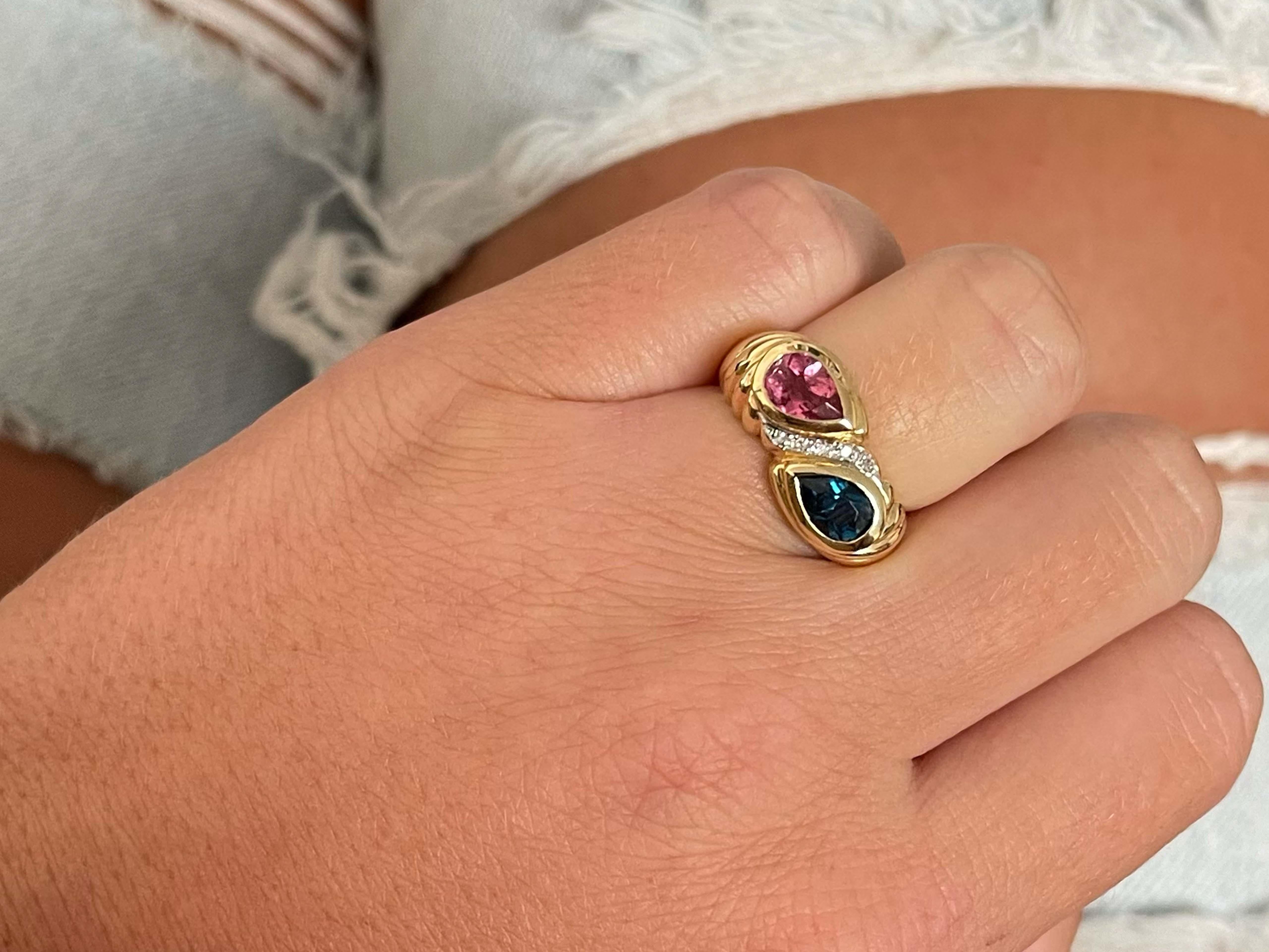 Item Specifications:

Metal: 14K Yellow Gold

Style: Statement Ring

Ring Size: 5.5 (resizing available for a fee)

Total Weight: 6.1 Grams
​
​Diamond Carat Weight: ~0.05 carats

Gemstone Specifications:

Gemstones: 1 pink and 1 indicolite