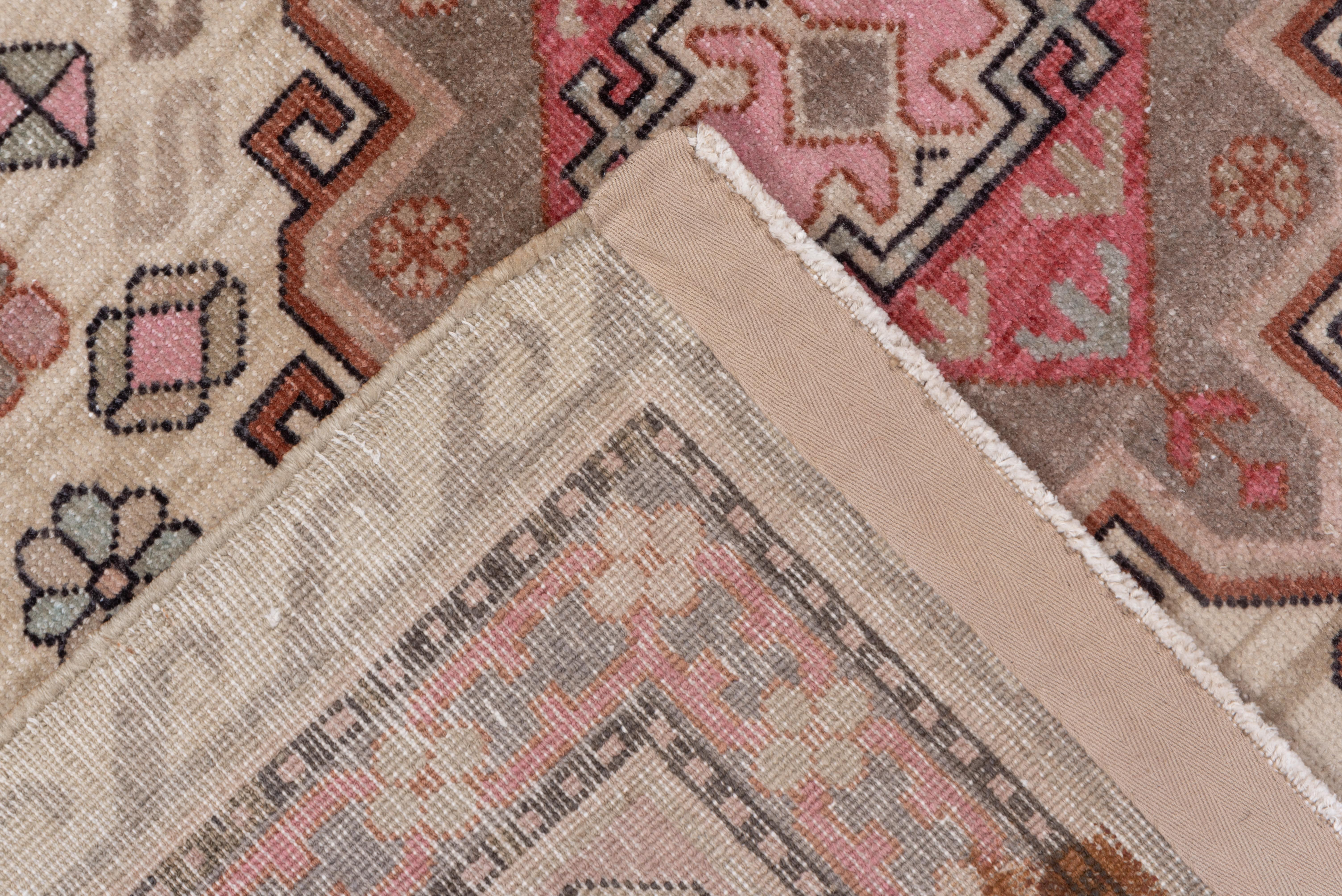 Khotan ist die aktivste der drei chinesisch-turkestanischen Teppichproduktionsstädte, und dieses cremefarbene, mit drei Stacheln und Haken versehene Medaillon ist ein gutes Beispiel für die Zwischenkriegsproduktion. Im Hintergrund sind ein Stern,