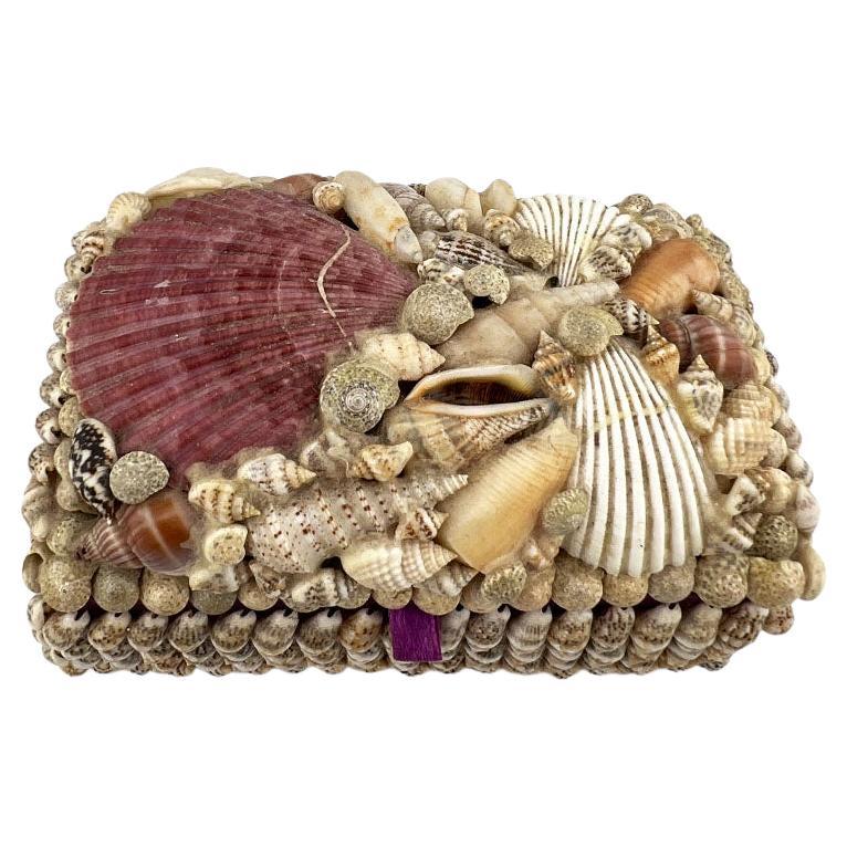 Elevate your space with this exceptionally rare vintage seashell box, a true testament to artisanal craftsmanship and natural beauty. Adorned with a curated arrangement of hand-selected seashells in soft lavenders, rose-pinks, creams, and ivory,