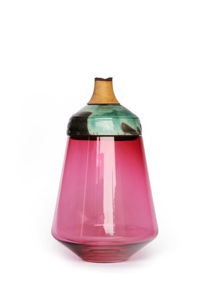 Pink and turquoise ruby stacking vessel, Pia Wüstenberg
Dimensions: D 18 x H 37
Materials: glass, wood, ceramic
Available in other colors.

The Ruby stacking vessel, inspired by the reflections on gems, is characterised by the vivid colour of