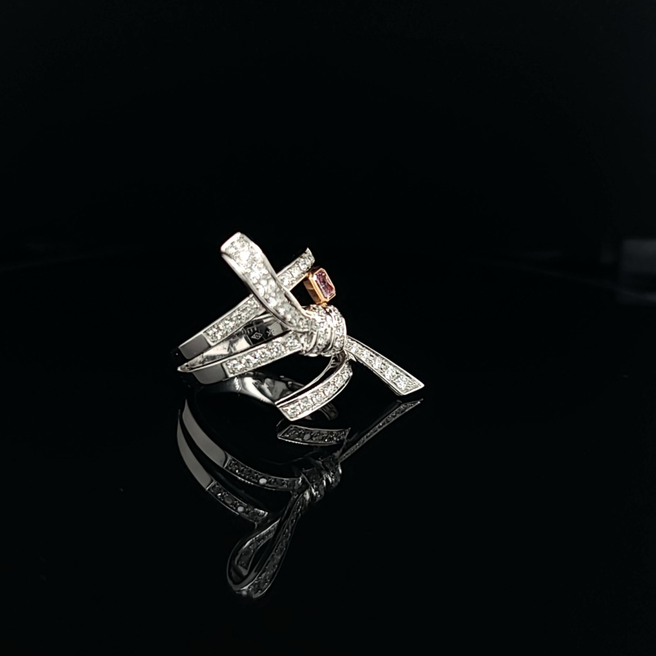 Bow ring featuring a 0.31 carat pink diamond radiant accented by 1.00 carats white diamonds. Set in 18k rose and white gold. Stock size 6.5 and can be adjusted per request.