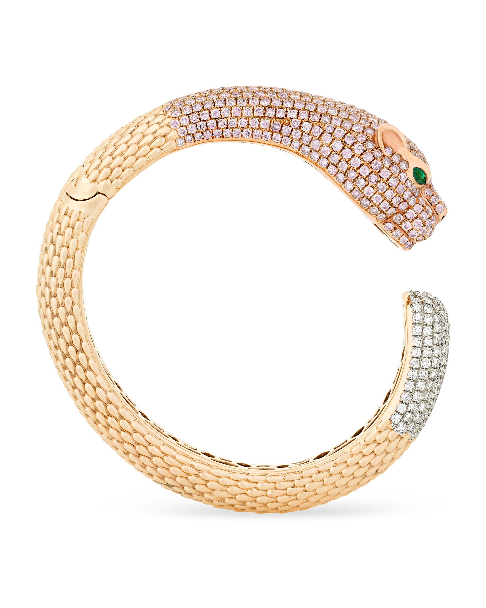 Fierce and boldly feminine, this chic 18K gold bangle bracelet takes the form of a panther accentuated by both pink and white diamonds. The pink diamonds total 8.43 carats, while the white diamonds weigh a combined 2.38 carats. The goldwork on this