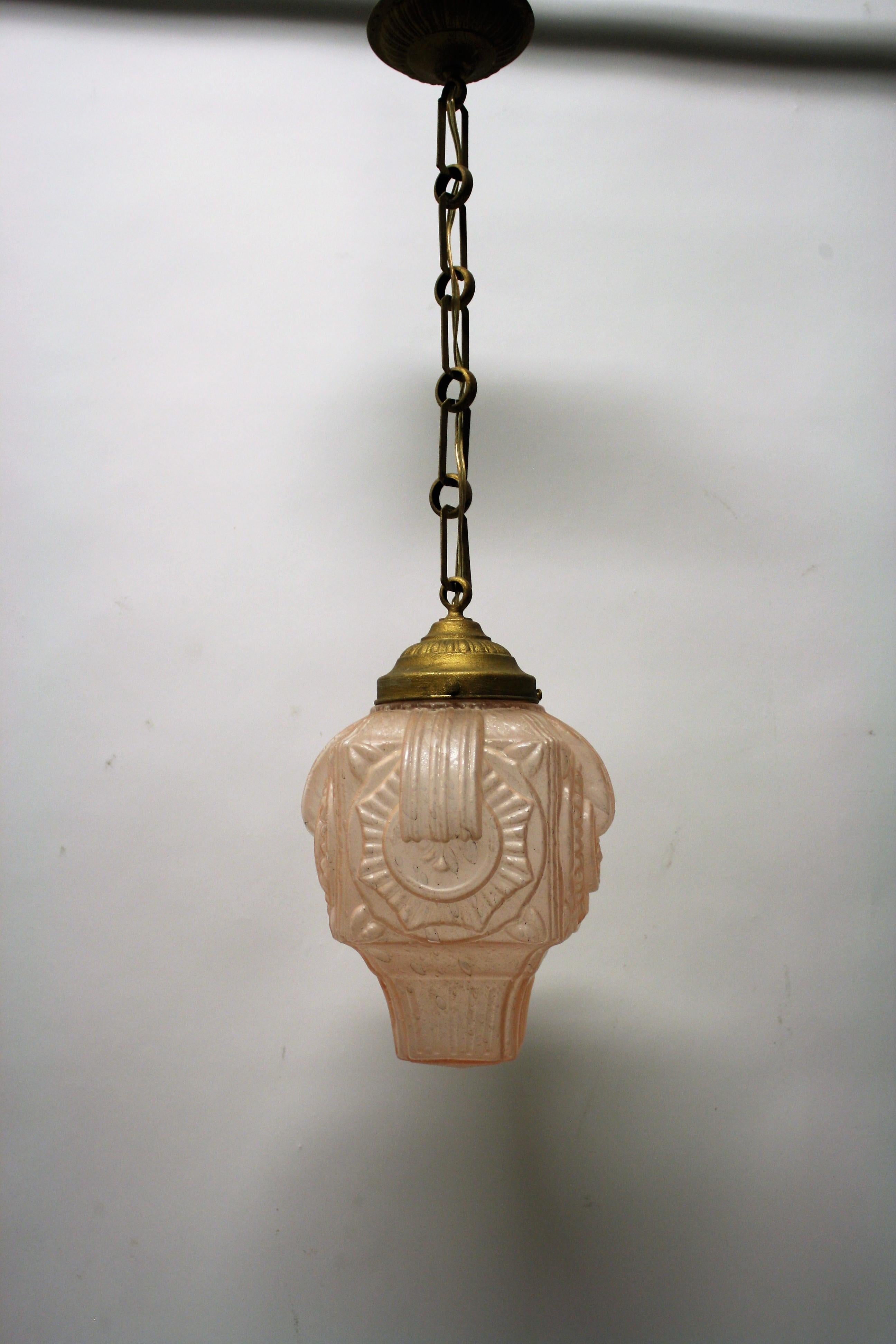 Original 1930s art deco pendant light made from pink crackled glass.

The lamp emits a beautiful warm light.

Good condition, tested and ready to use with a regular E26/E27 light bulb.

It comes with a period shade holder, chain and ceiling