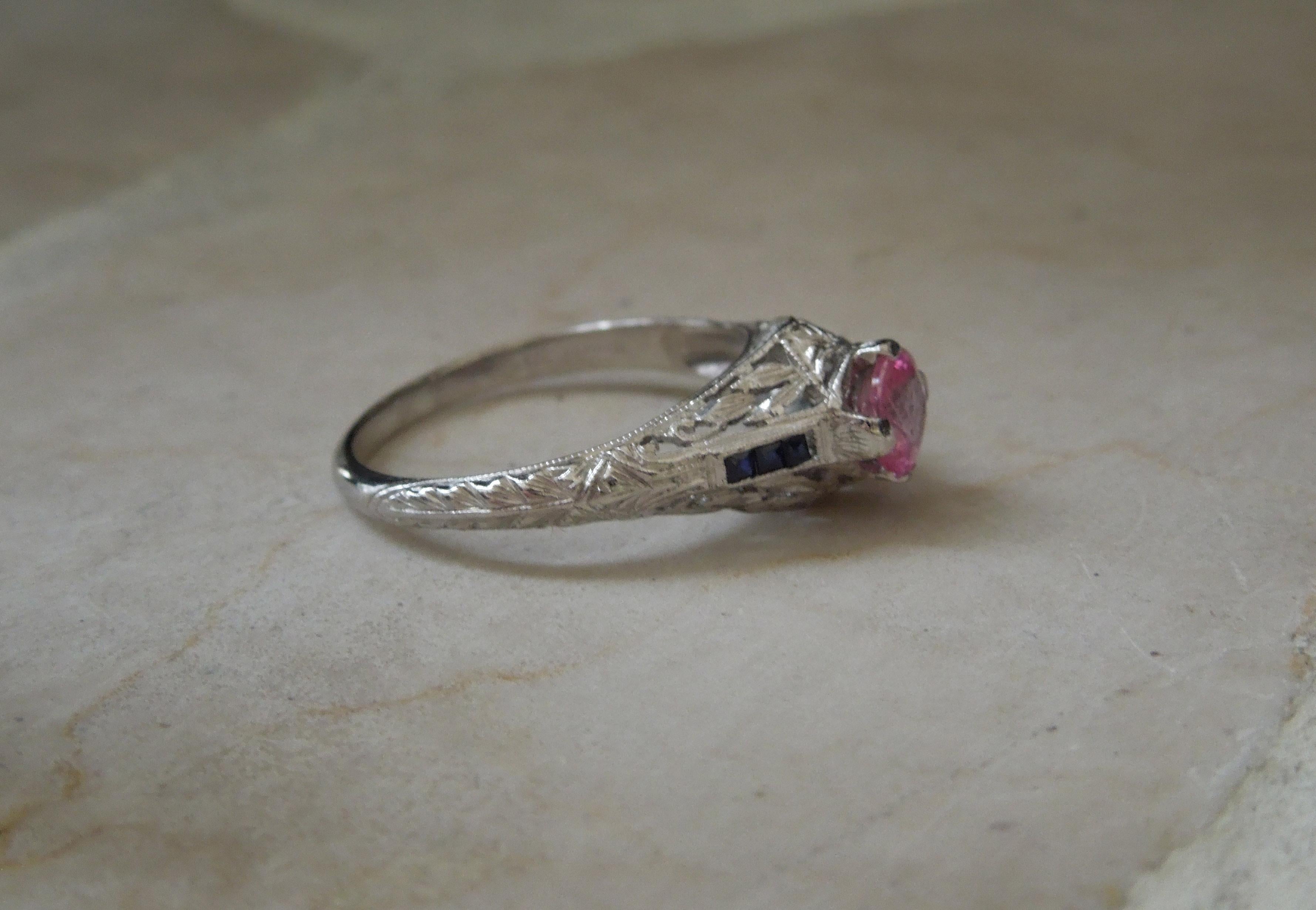 From a local New Orleans estate, this Edwardian Pink & Blue Sapphire Ring features a central 0.54 carat Natural Intense Vivid Pink Sapphire at 4.8mm in diameter. Among the rarest colors of Sapphires in today's market, as well as Sapphire being the