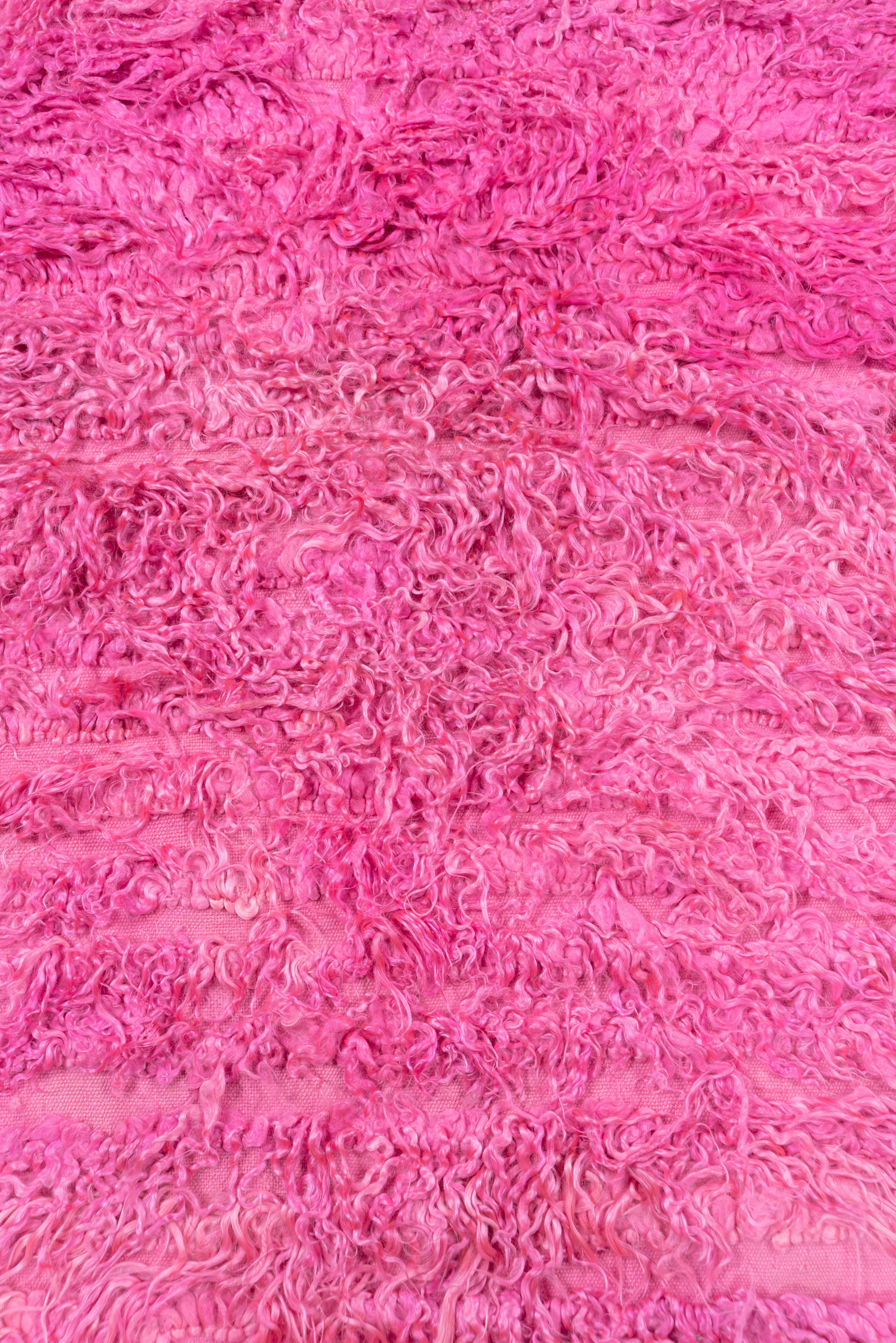 This central Anatolian village Tulu is totally pink, both in the long shaggy pile and in the multi-wefted foundation. Abrash, but no borders or pattern.