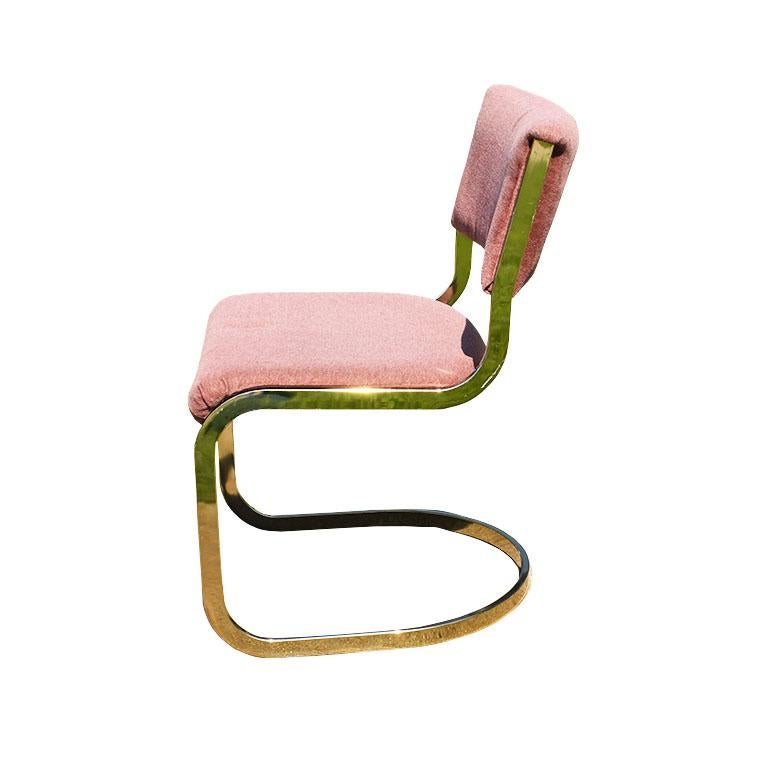 A beautiful pair of pink upholstered Cal style chairs with cantilever bases. Each chair features gold cantilever bases, with upholstered pink seats. The backs are upholstered in the same pink fabric on both the front and backs. This set would be a