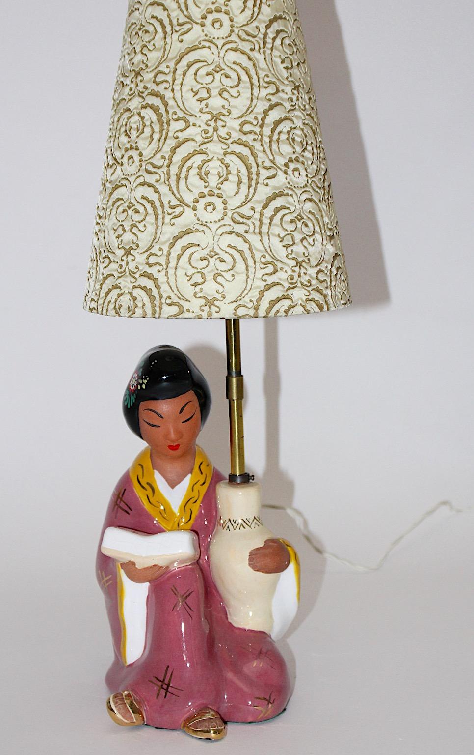 Mid Century Modern vintage pink ceramic Geisha Chinoiserie table lamp by Carli Bauer 1950s Austria.
Amazing ceramic table lamp with geisha like base in soft pink and pastel color tones with lamp shade.
The table lamp underlines the far east