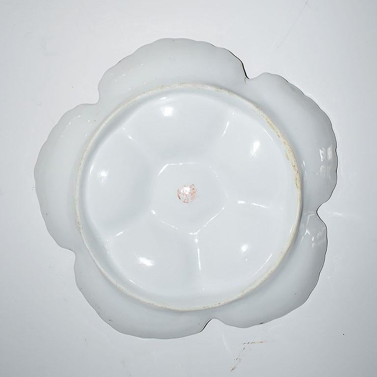 Pink ceramic oyster or shell plate. This piece includes five clam shell shaped areas for oysters or mussels and a dip in the center for the sauce. The edges are scalloped and painted in gold.

Signed Limoges France at the bottom. Circa