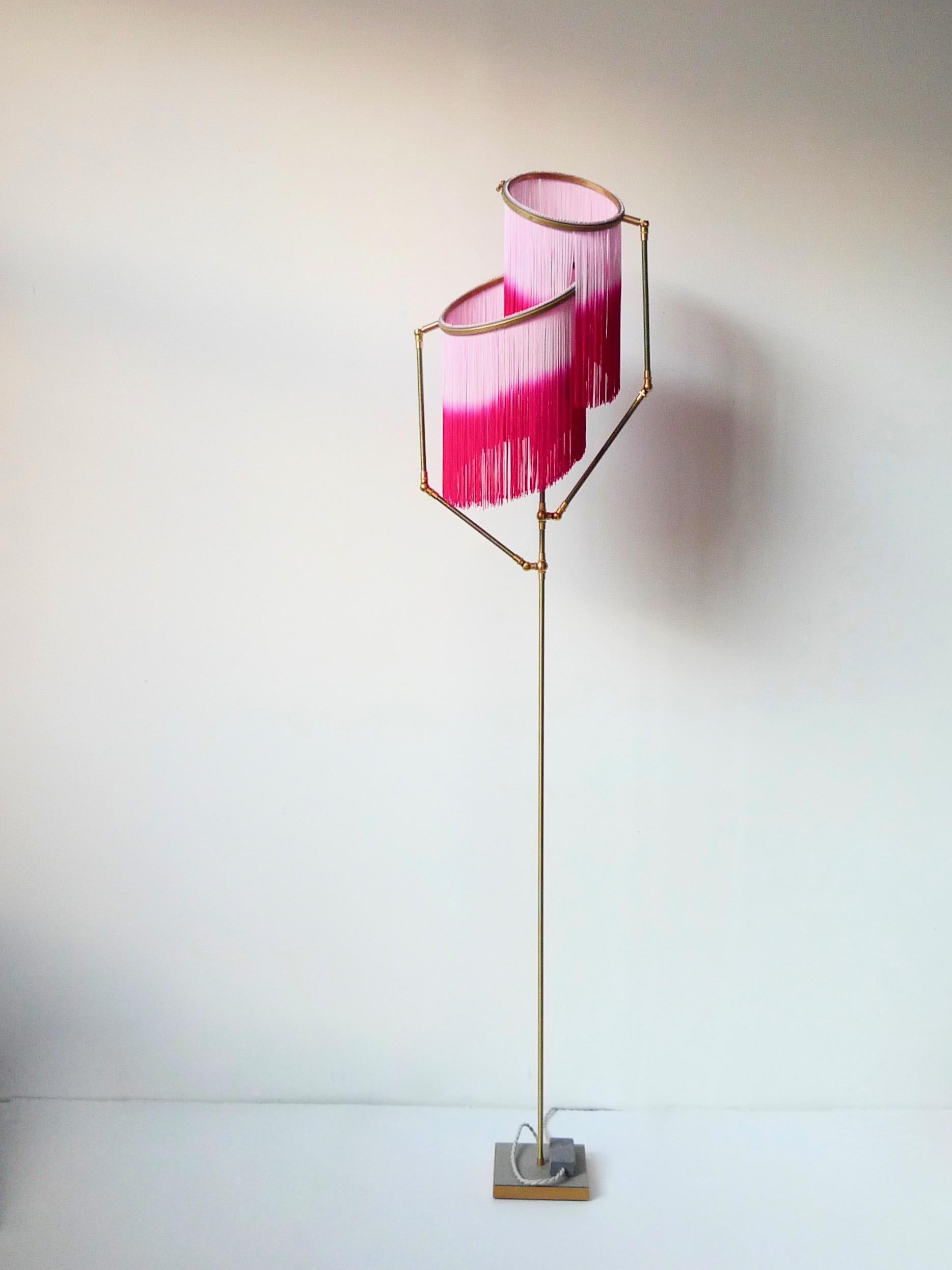 Pink charme floor lamp, Sander Bottinga

Dimensions: H 153 x W 38 x D 25 cm
Handmade in brass, leather, wood and dip dyed colored Fringes in viscose.
The movable arms makes it possible to move the circles with fringes in different positions.
So