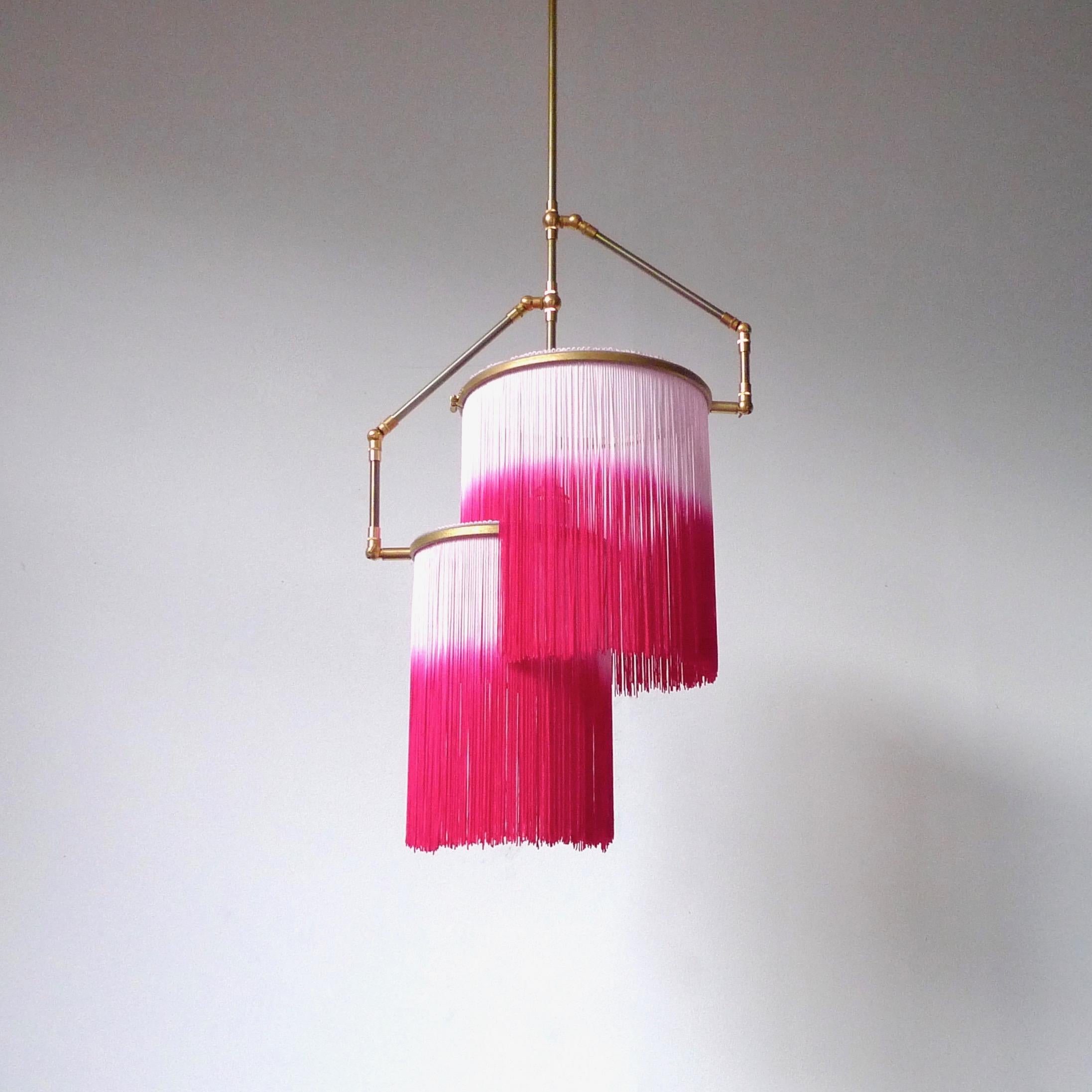 Pink Charme pendant lamp, Sander Bottinga

Dimensions: H 65 (can be customized) x W 38 x D 25 cm
Hand-Sculpted in brass, leather, wood and dip dyed colored Fringes in viscose.
The movable arms makes it possible to move the circles with fringes