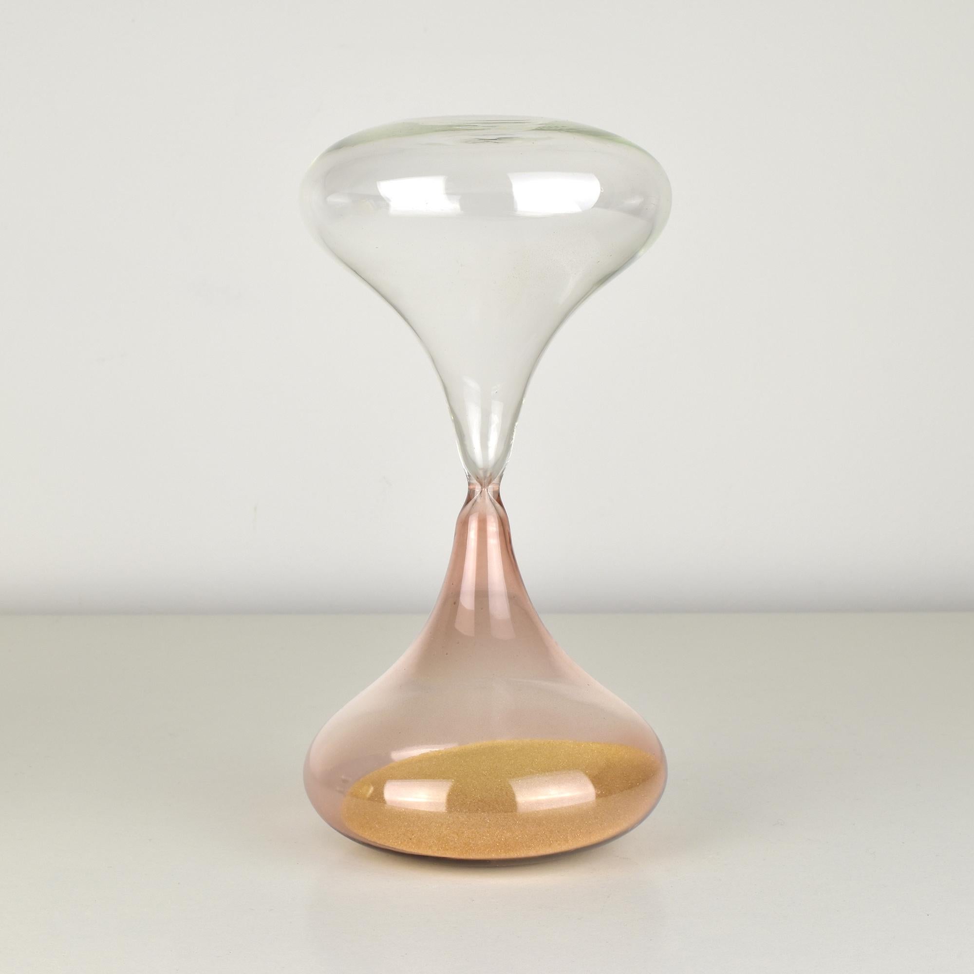 A hand blown art glass hourglass made of pink and clear glass in style of Paolo Venini.