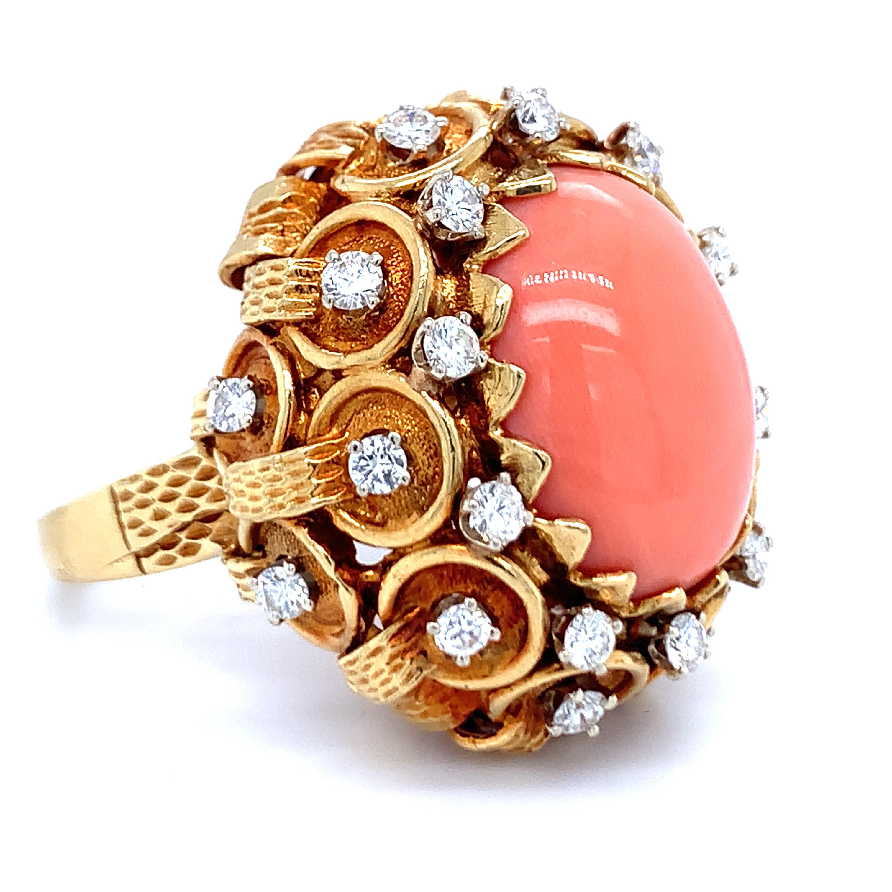Bague en or jaune 18 carats, corail rose et diamant, ornée d'une pierre ovale en corail rose mesurant 20 x 15 millimètres. La bague est également rehaussée par vingt-quatre diamants ronds de taille brillant totalisant 1,50 ct. de couleur H et de