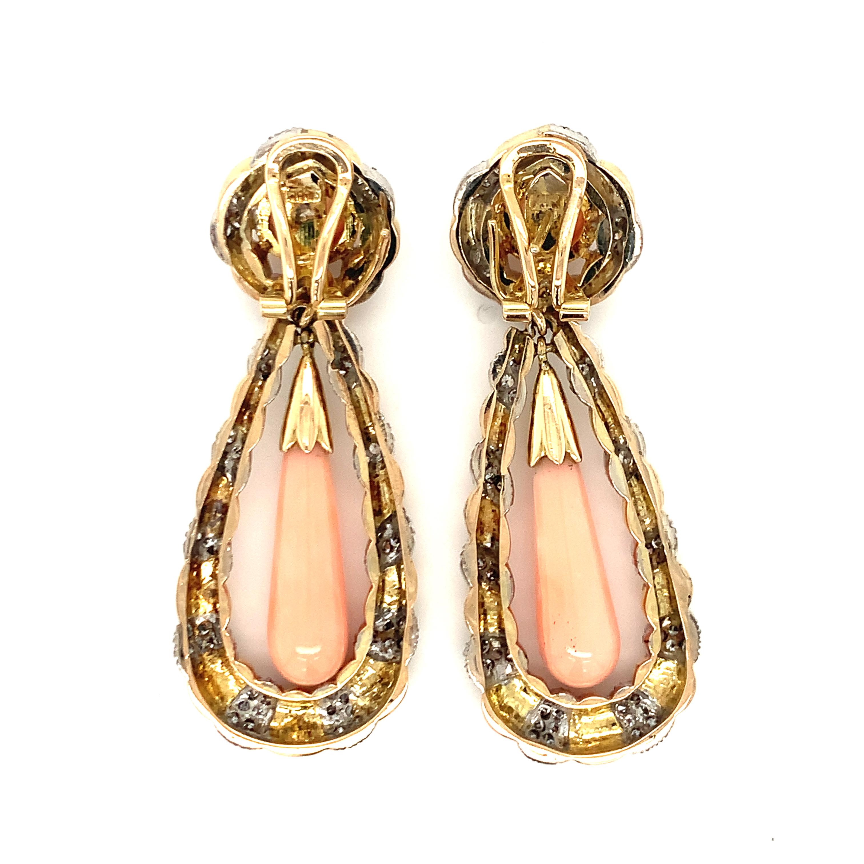 One pair of pink coral and diamond dangling 14K yellow and white gold earrings featuring four coral portions – two round cabochons (8 mm. diameter) and two pear drop portions (20 mm. long). The earrings also feature 128 single round cut diamonds