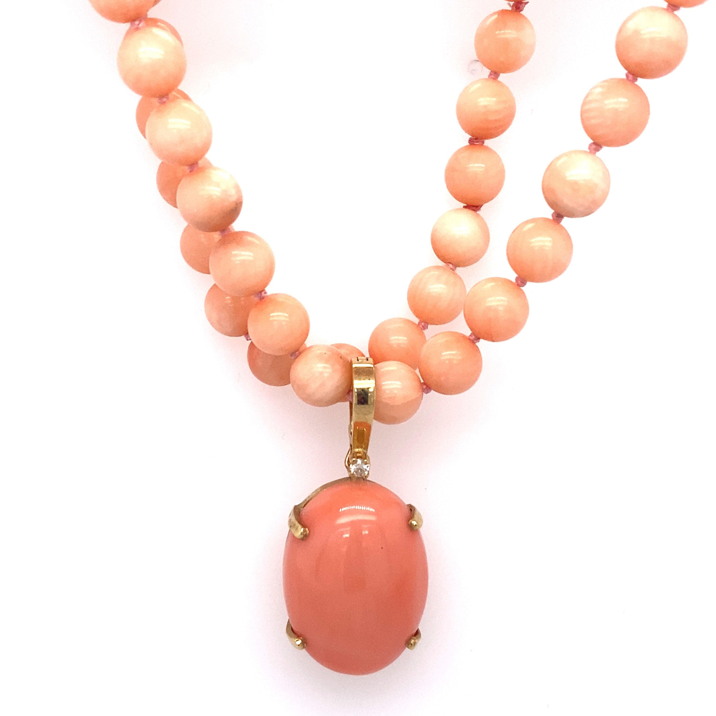 This high quality pink coral necklace has a striking pink oval enhancer in 18 Karat Gold with a small diamond accent. Clasp is 14 Karat Yellow Gold. The pendant is 4 prong set. 

Circa: 1980s
Metal Type: 18 karat yellow gold
Weight: 26.7