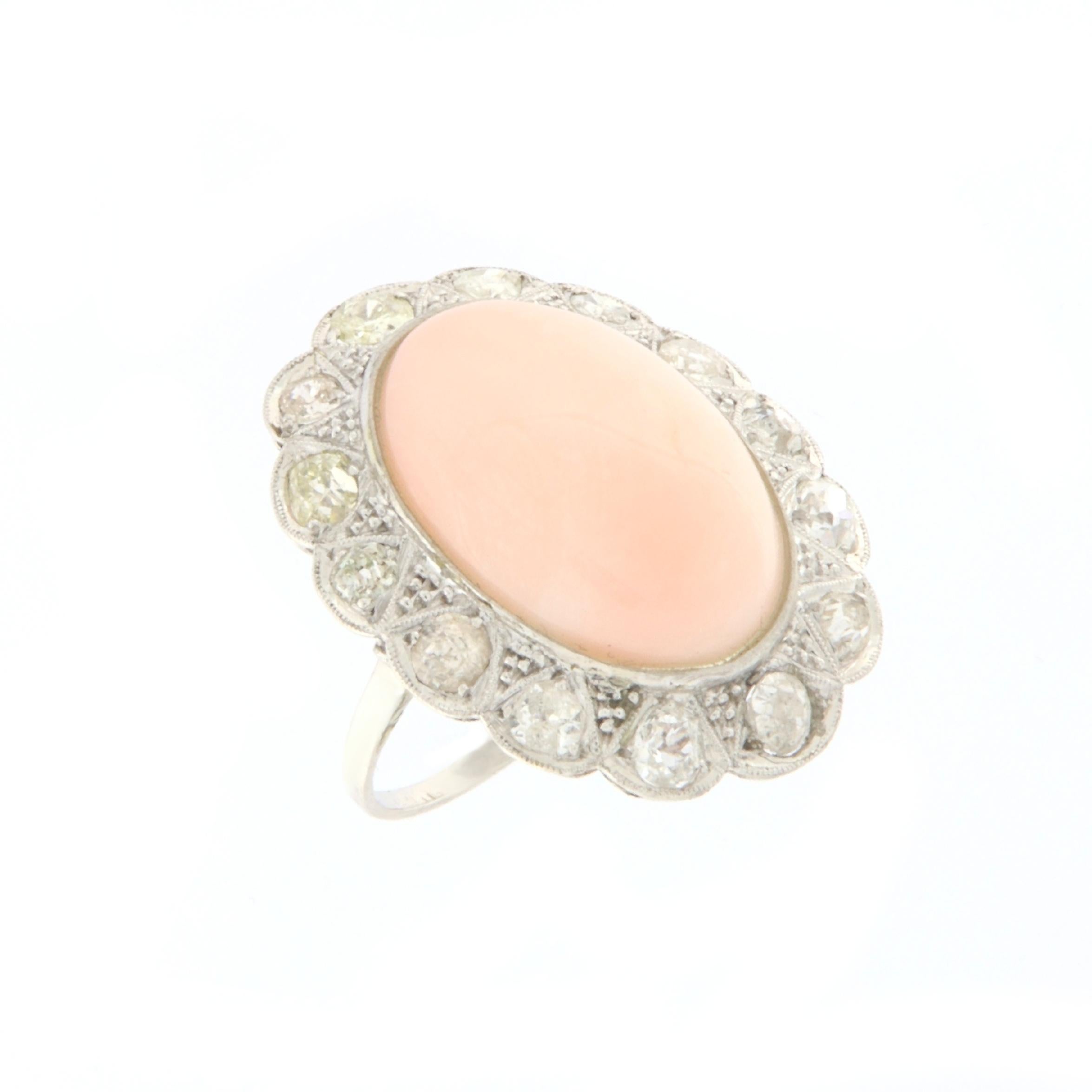 This exquisite ring in 18-karat white gold evokes the timeless elegance of antique style, offering a perfect balance between classicism and contemporary charm. At the heart of this majestic creation stands a spindle of pink coral, chosen for its