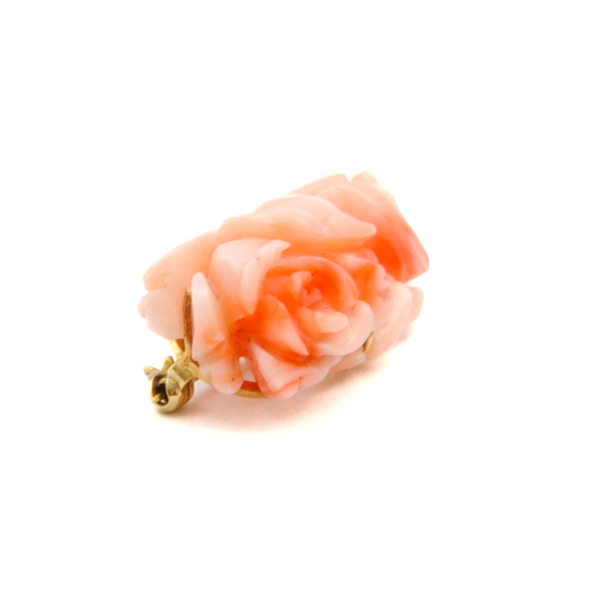 Eine rosa Korallenbrosche im Vintage-Stil in einer goldenen Fassung. Die Koralle ist zu einer schönen blühenden Rosenblüte geschnitzt und auf der Rückseite mit einem Goldrahmen versehen. Die Koralle gilt als Symbol für Erneuerung, Vitalität und