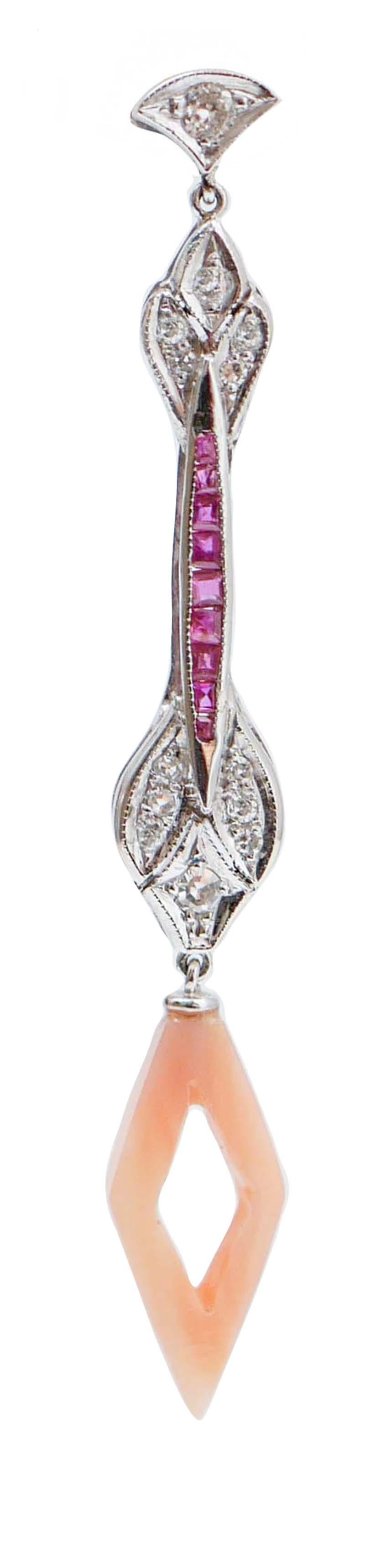 Fantastic dangle earrings in platinum structure mounted with rubies in the middle part between structures studded with diamonds. As pendant, a pink coral.
These earrings were totally handmade by Italian master goldsmiths and they are in perfect
