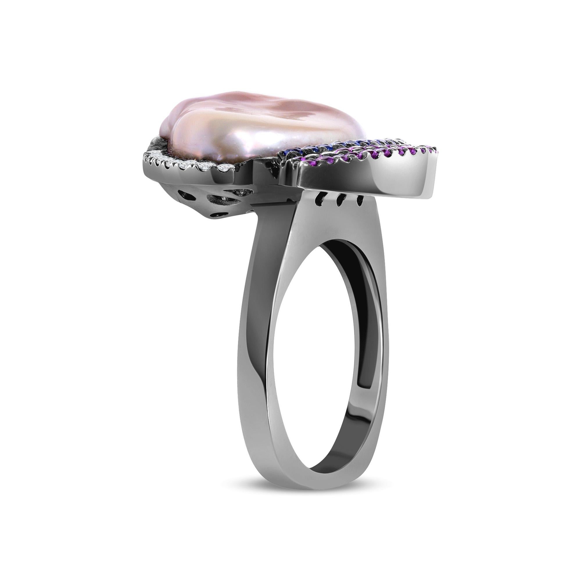 Natural Pink Cultured Pearl Pink and Blue Sapphire Diamond White Gold Rhodium Cocktail Ring. This cocktail ring is made of 18k white gold with black rhodium plating. This ring features a large wave-shaped, natural pink color, cultured pearl. Around