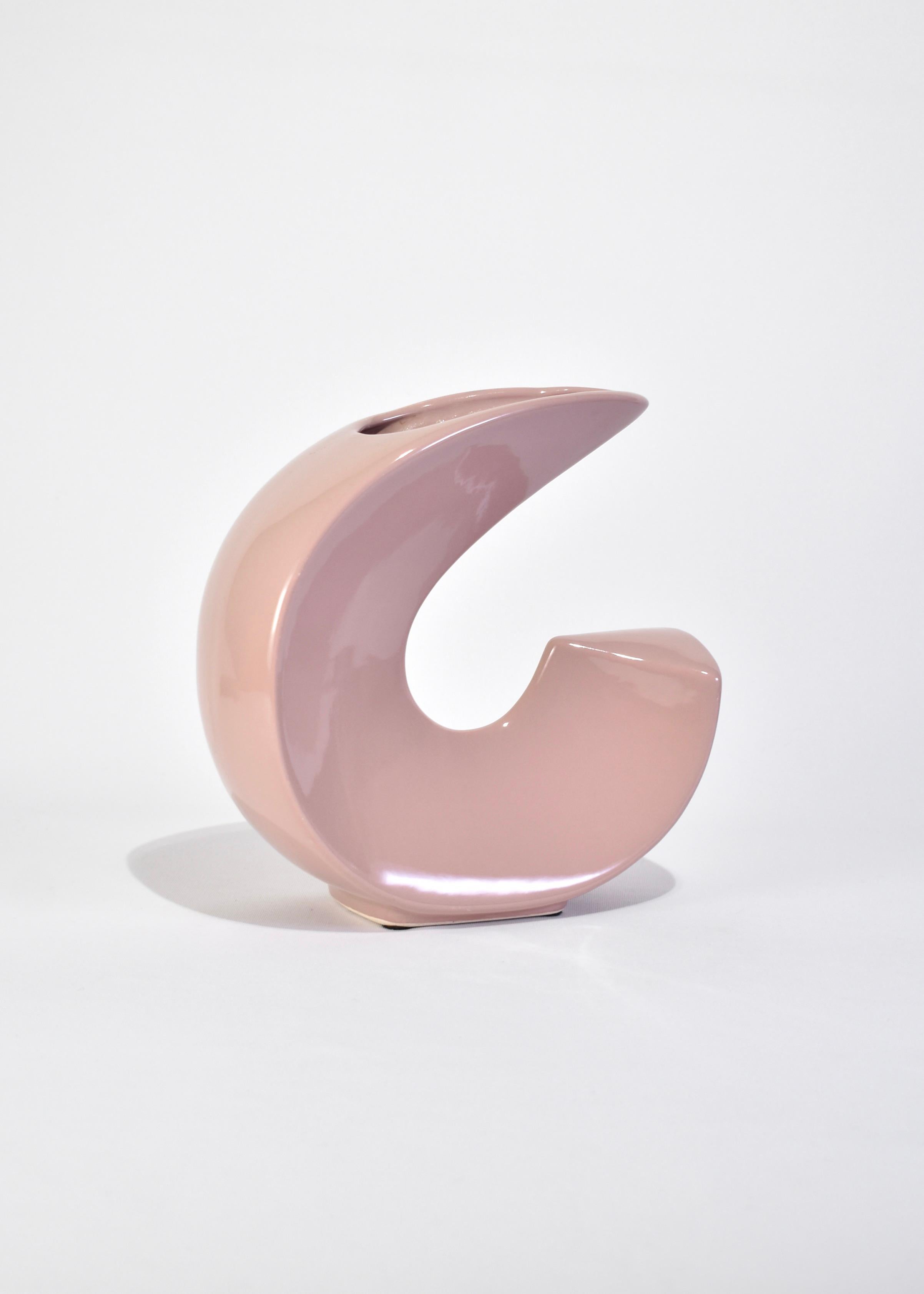 Vintage ceramic vase in a curved shape with glossy light pink glaze. Stamped on base.