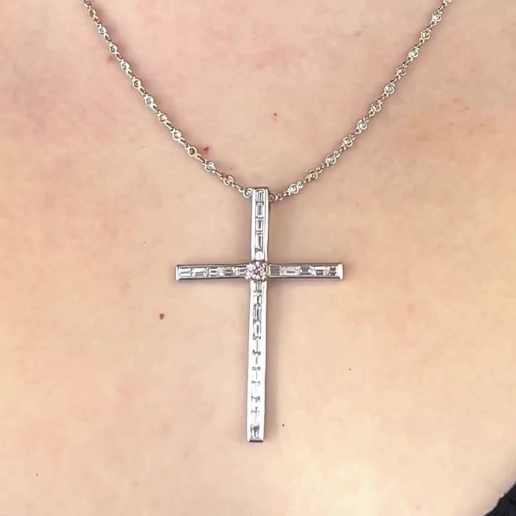One Pink Diamond 18 Karat Platinum Cross Necklace. Featuring one round brilliant cut pink diamond with a weight of approximately 0.15 carat, graded fancy intense pink color. Accented by twenty six baguette cut diamonds with a total weight of