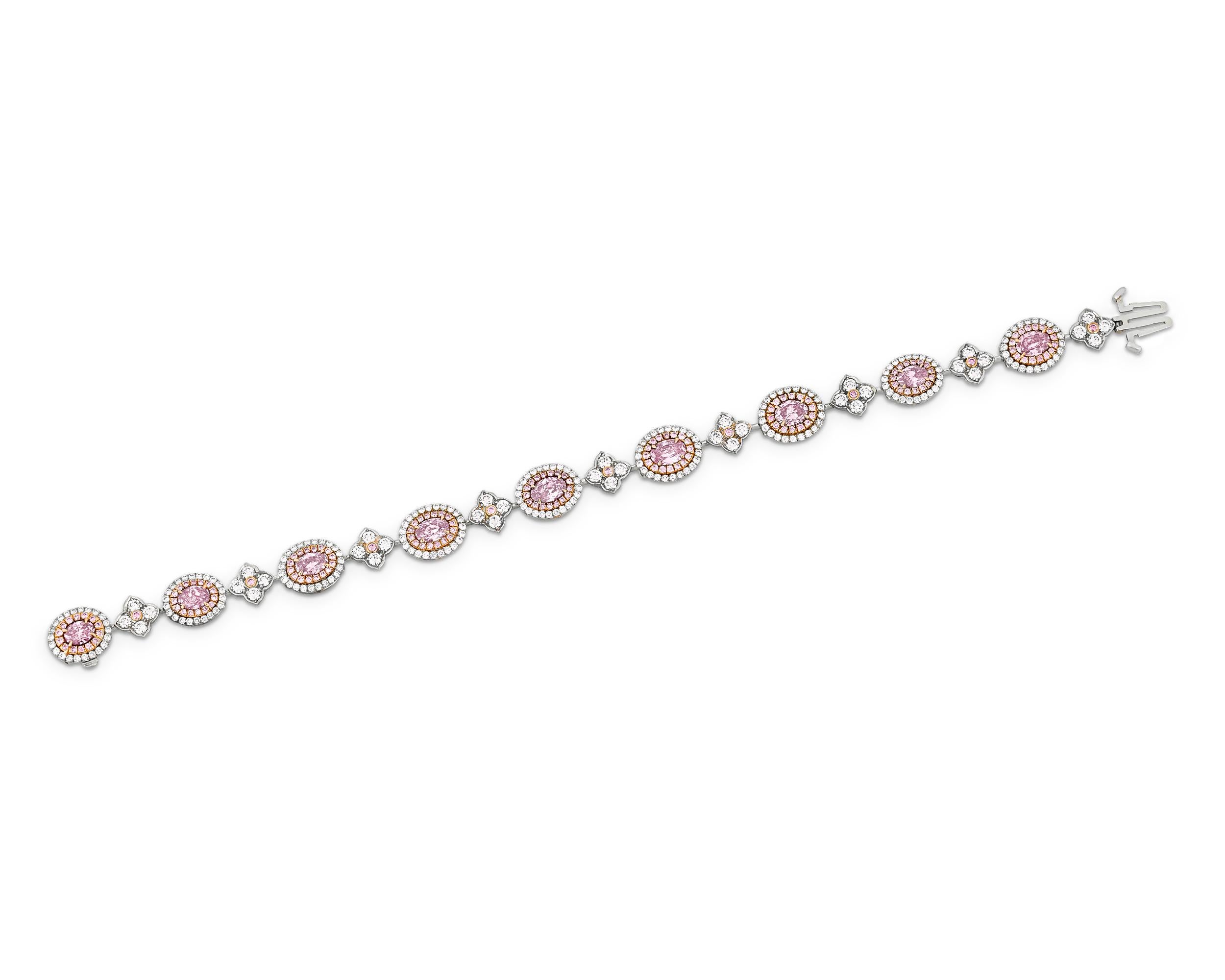 A dazzling array of pink and white diamonds shine with amazing intensity in this bracelet. Nine oval-shaped fancy intense colored diamonds ranging in color from pink to purple-pink and weighing 2.73 total carats dot the length of the bracelet while